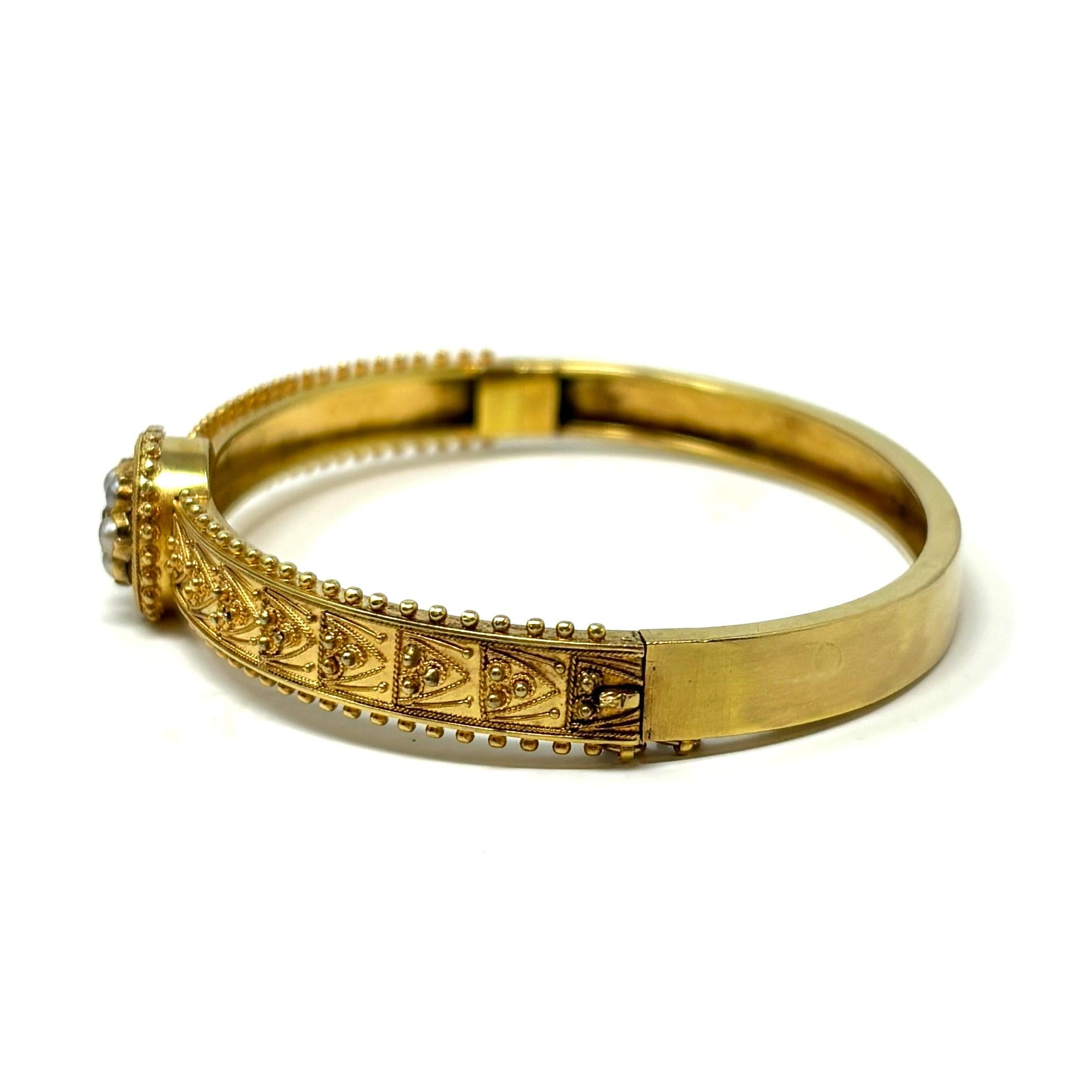 Dieser hübsche Armreif im etruskischen Revival-Stil zeichnet sich durch eine Gruppe zierlicher grauer Perlen aus, die einen Diamanten mit altem Minenschliff umgeben, sowie durch exquisite Granulation und Drahtarbeit.

Cica 1870er-80er Jahre

3/8