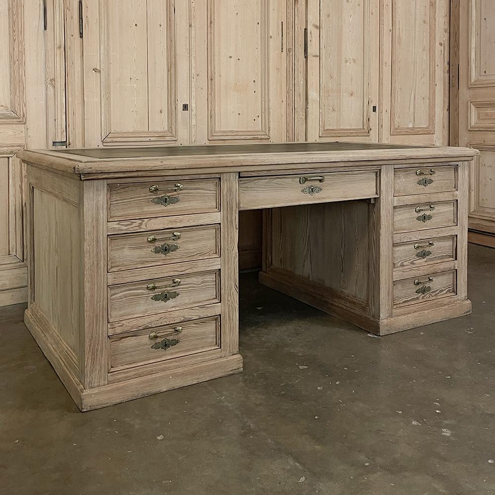 Antique English executive desk with faux leather in stripped pine is the perfect choice for busy and important people! Crafted on a larger scale than normal, it features no less than nine drawers on the chair side, with two cabinets on the room