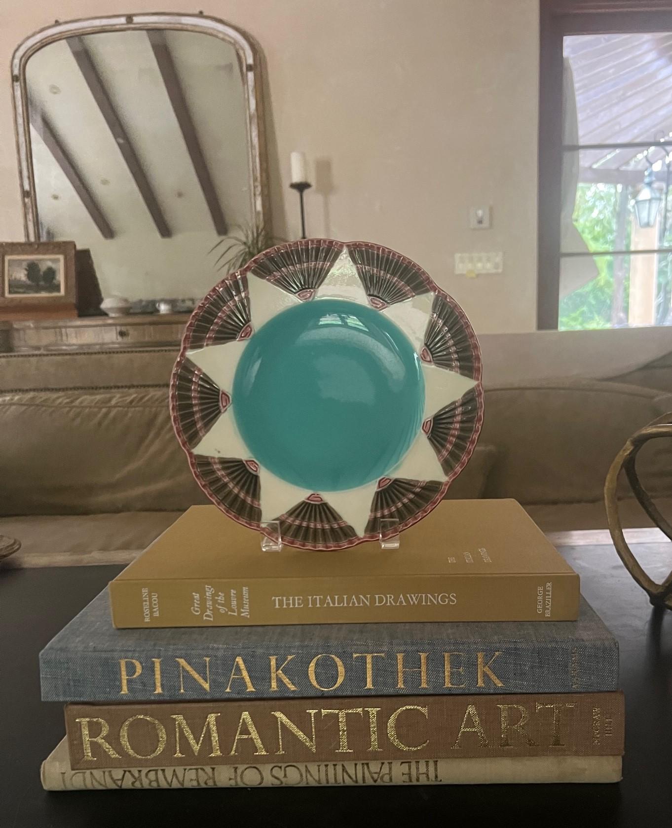 19th Century plate made in England by Wedgwood, the pattern, part of the Fan collection is called Argenta Chicago. It has a turquoise center surrounded by a star pattern and fans. 

In 1879, nineteen years after it first started majolica