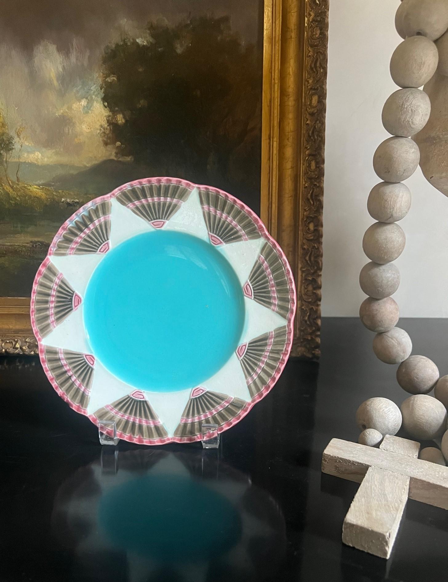 19th Century plate made in England by Wedgwood, the pattern, part of the Fan collection is called Argenta Chicago. It has a turquoise center surrounded by a star pattern and fans. 

In 1879, nineteen years after it first started majolica