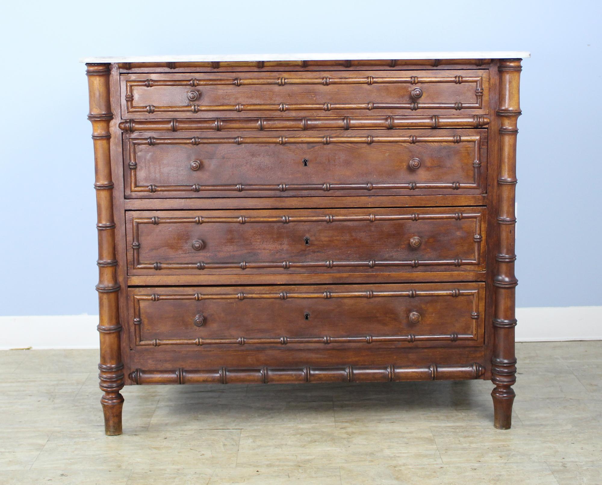 A charming chest of drawers with faux bamboo columns and mouldings. Four roomy drawers. The marble which is original is in good antique condition.