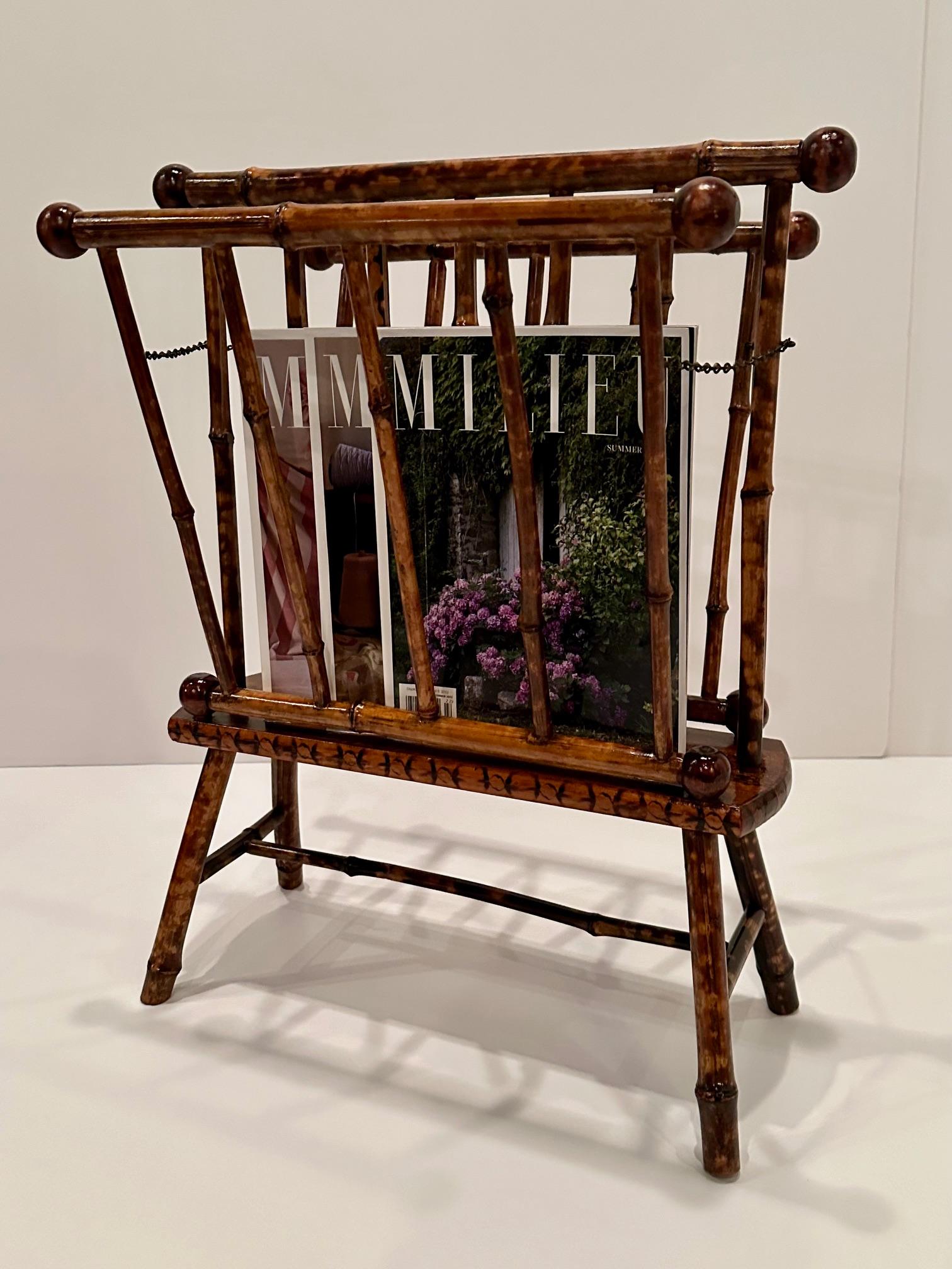Elegant antique English Edwardian faux tortoise shell and bamboo magazine rack having hand stenciled base and brass chain.  The stand folds for easy shipping.
