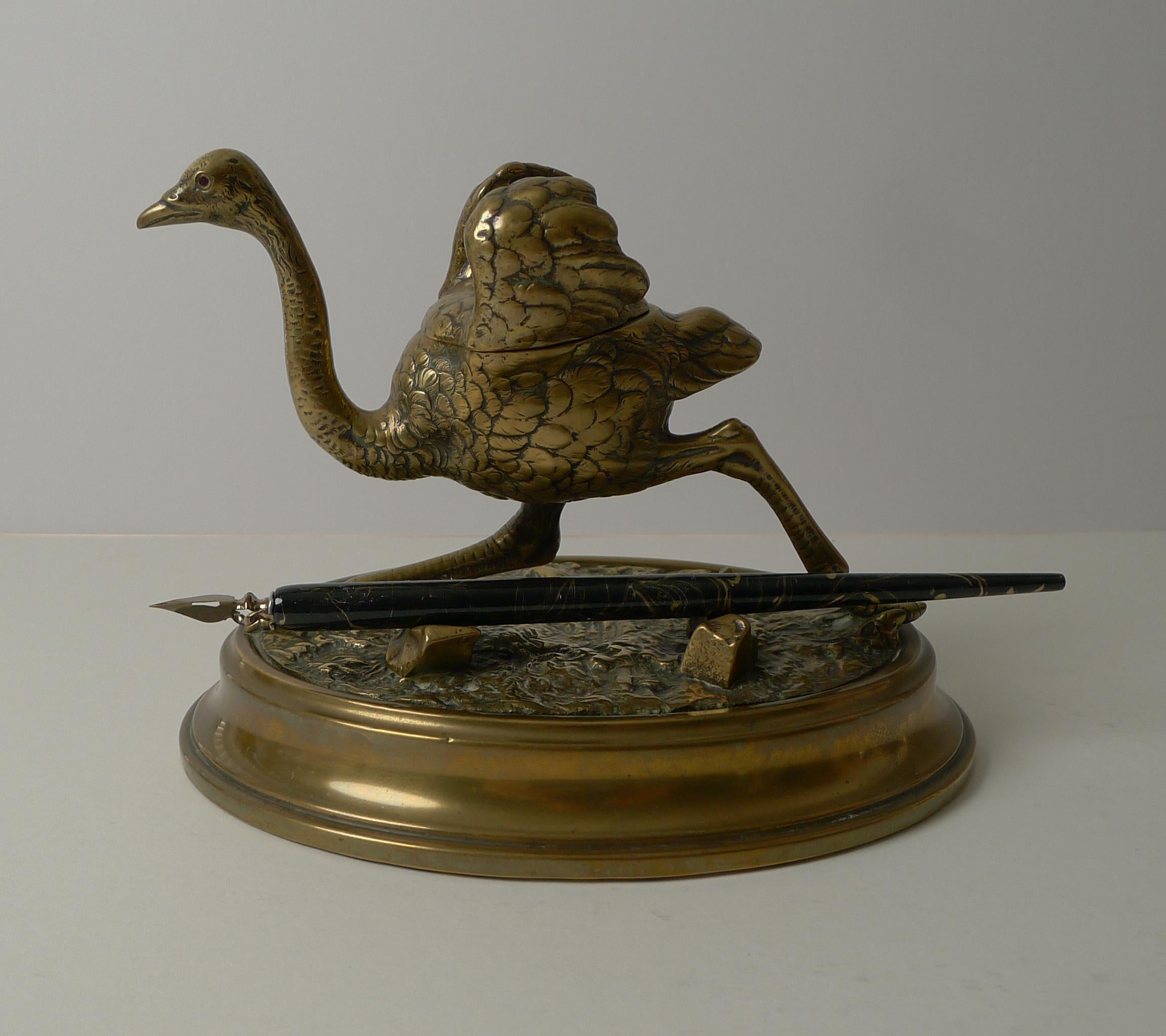 A handsome and substantial novelty inkwell in the form of a running Ostrich standing on an oval shaped base with a naturalistic base incorporating two 