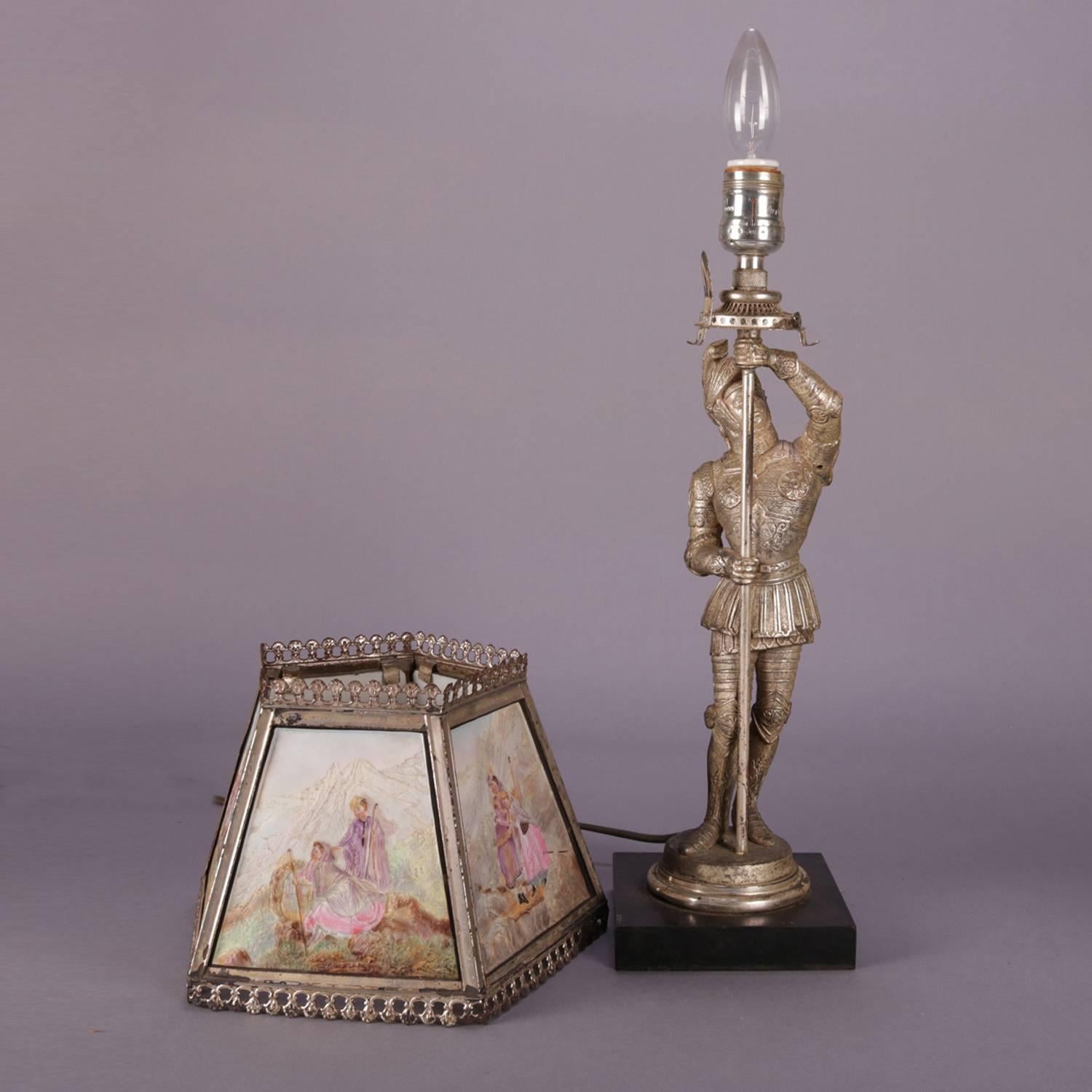 Antique English figural lithophane table lamp features base with full length portrait sculpture of knight in shining armor, shade with five painted lithophane panels depicting genre and landscape scenes, circa 1900.

Measures: 21