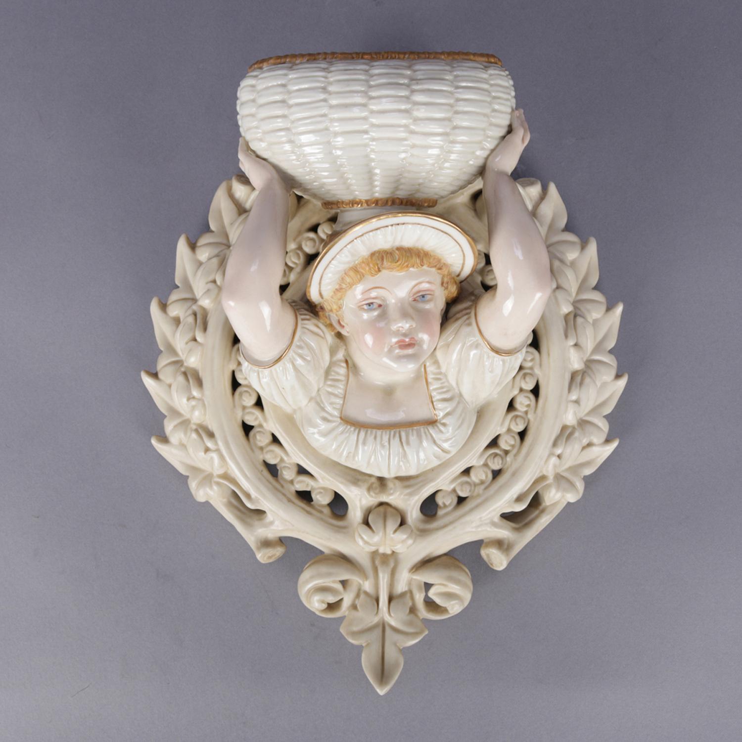 An antique English figural wall pocket by Royal Worcester featuring porcelain construction with hand painted and gilt girl holding basket and encircled in ivy wreath, en verso maker stamp, circa 1880

Measures: 11.5