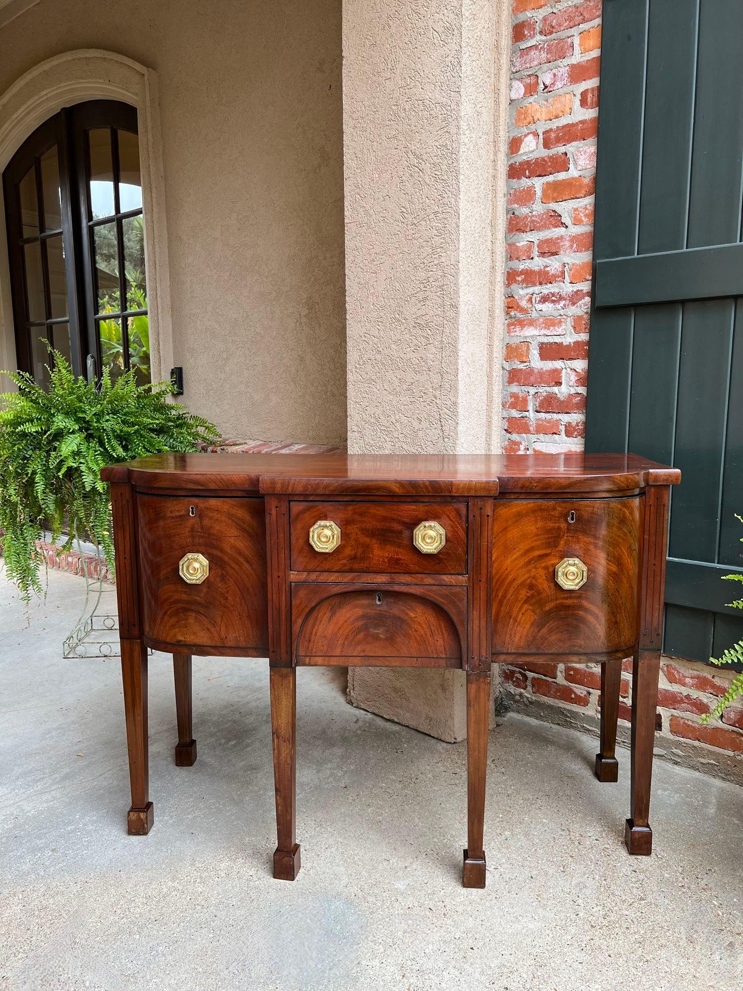 Antique English Flame Mahogany Buffet Sideboard Regency Neoclassical Style.

Direct from England, and full of British elegance and style, very “regency” or “neoclassical”. The shape is fabulous, with a serpentine front – notice even the side doors
