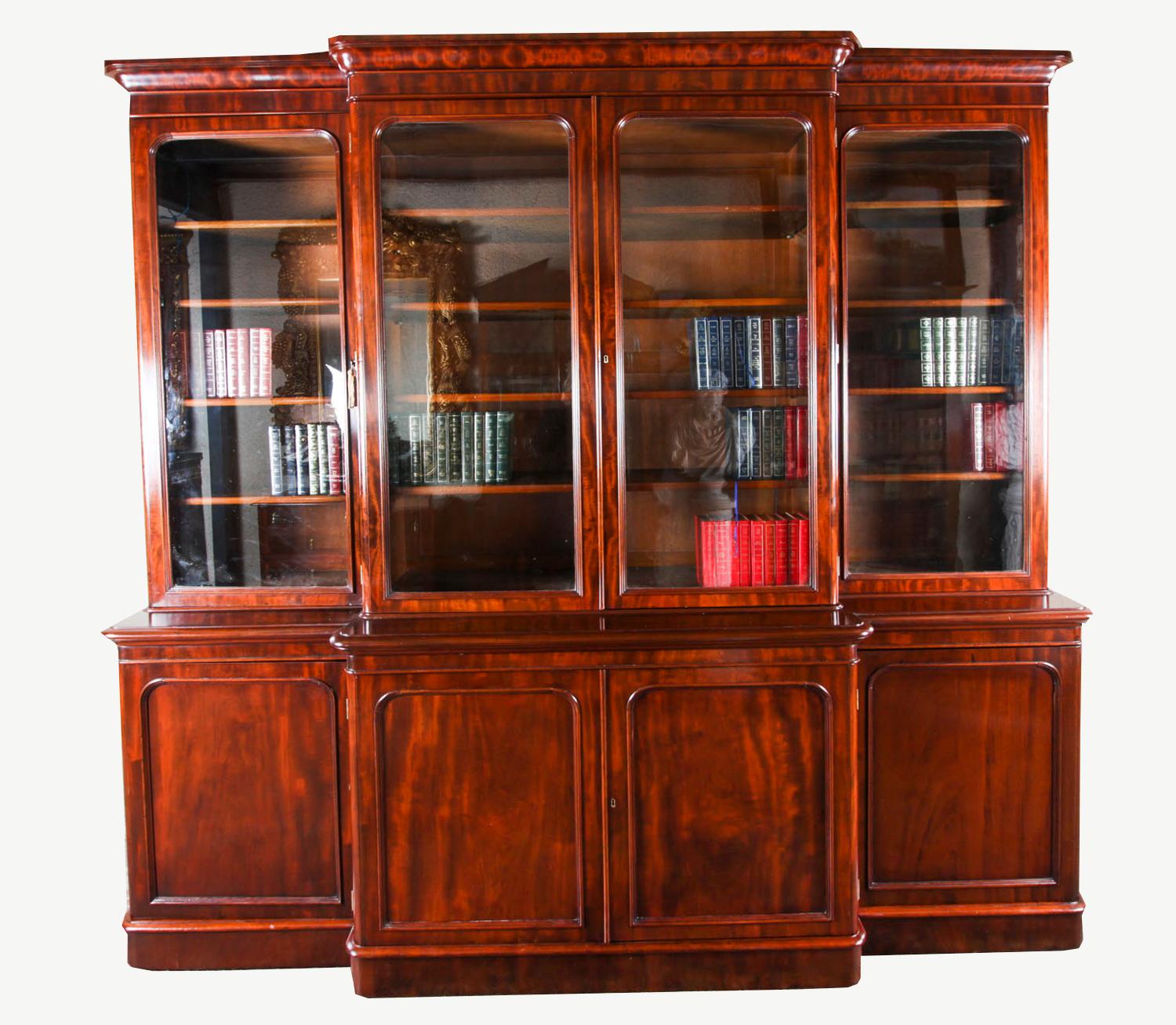 This is a beautiful antique Victorian flame mahogany four door library breakfront bookcase, masterfully crafted in rich solid mahogany, circa 1860 in date.
 
This magnificent bookcase features four glazed doors in the upper section revealing the