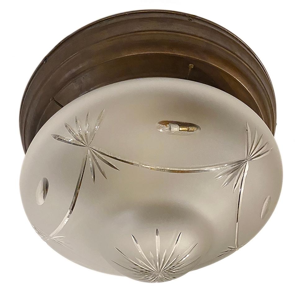 A circa 1920s English repoussé brass flush-mounted light fixture with frosted and etched glass inset.

Measurements:
Diameter 21