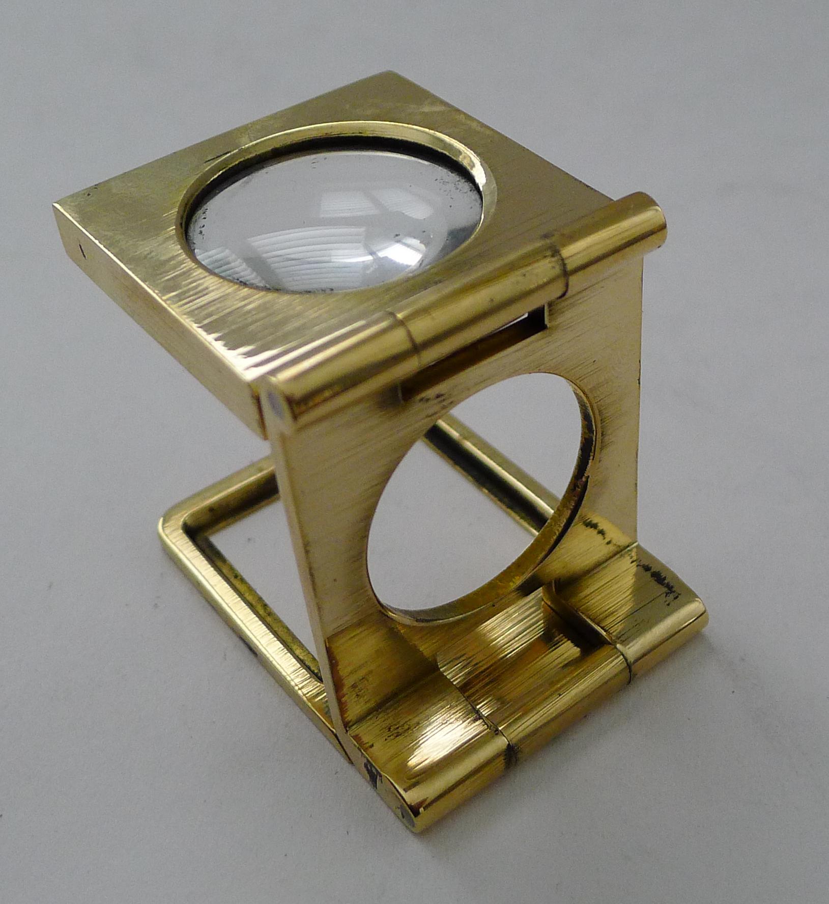 Dating to the early twentieth century, c.1900/1920, this is an antique cast brass linen thread counter, of course usable to magnify whatever you wish.

Heavy solid cast brass with a good undamaged magnifying glass, professionally cleaned and