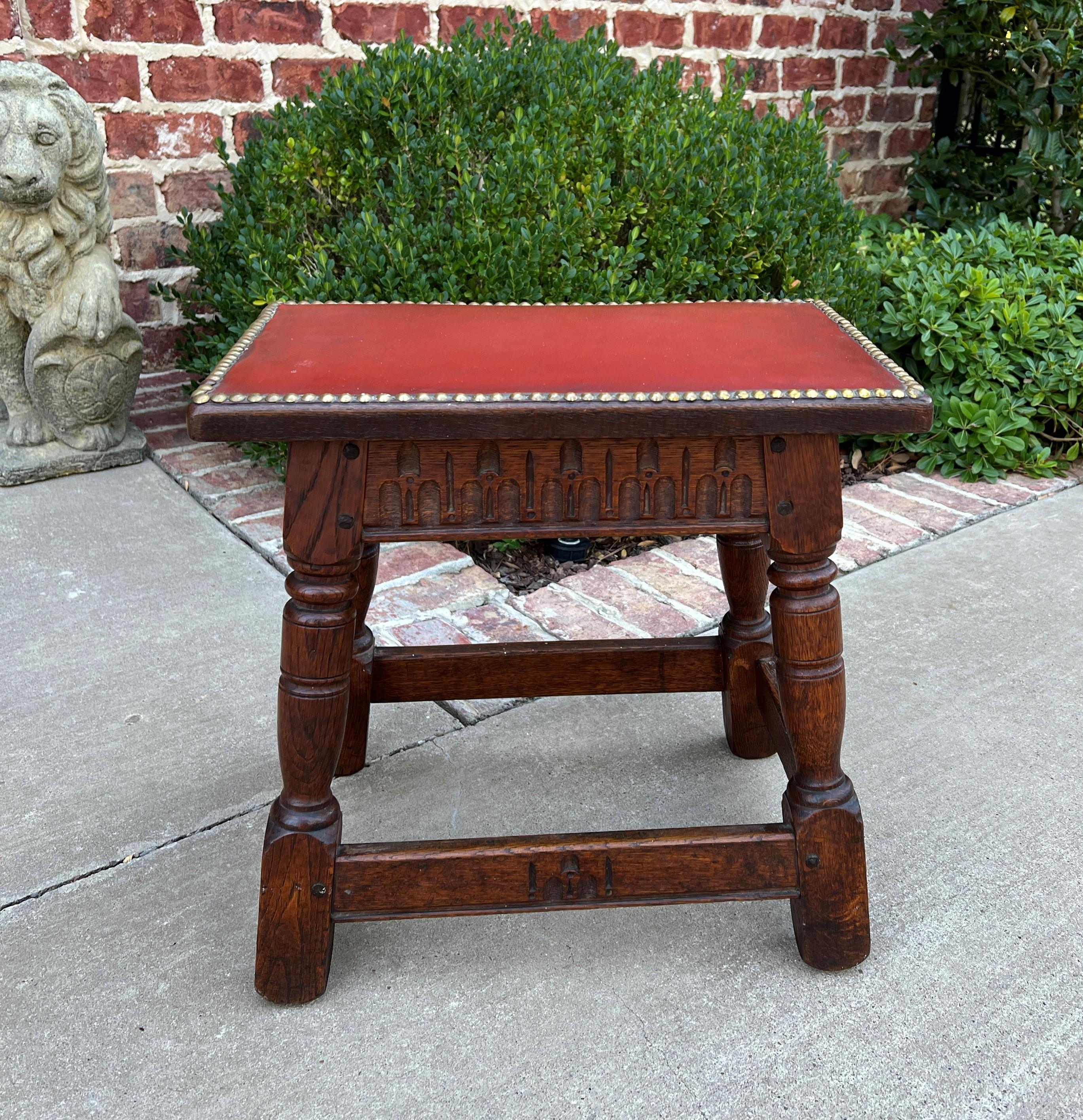 Charming antique English oak joint stool, footstool, or small bench with red leather top~~late 19th century

Classic British flair carved oak decorator piece with red leather top and brass tacks~~highly carved skirt and splayed legs~~old pegged
