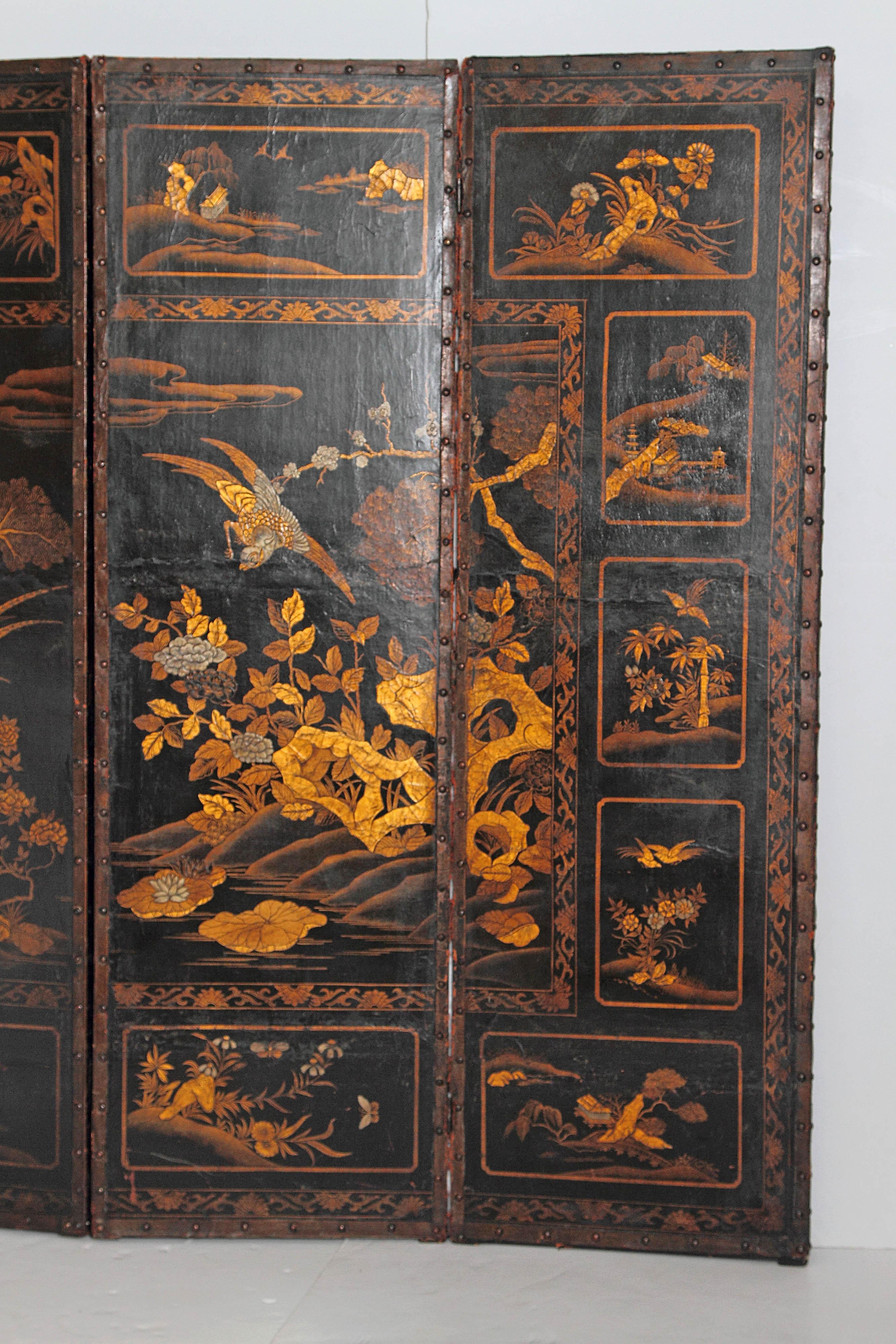 A very distinctive early 19th century English leather four-panel screen. Painted black with gold chinoiserie decorations of water birds, flowers, animals and architecture. Nice nail head trim around the border, early 19th century, England.