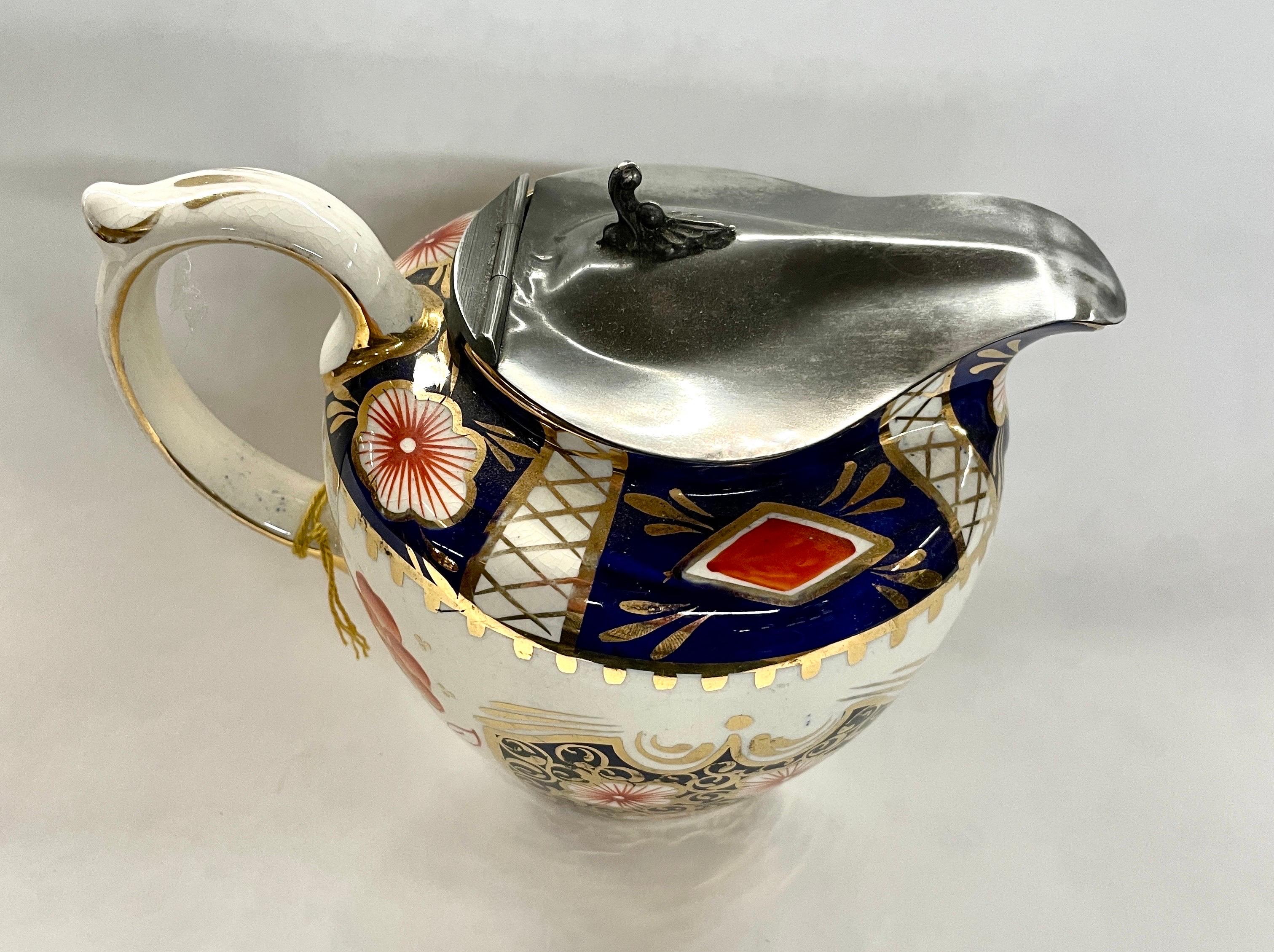 A gorgeous Antique English middle to late 19th century pewter lidded Imari decor Jug or Pitcher. The hand painted decor is similar to those originated by the Derby factory during the George III period, but this is a later 