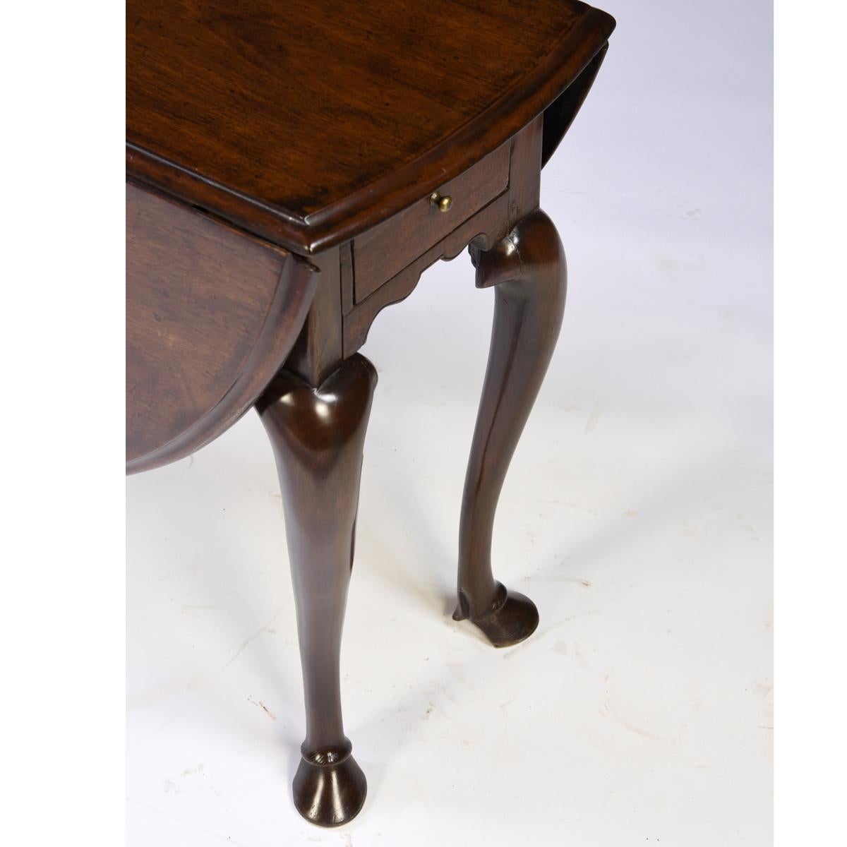A very rare antique English George II mahogany drop-leaf table with cabriole legs and carved 