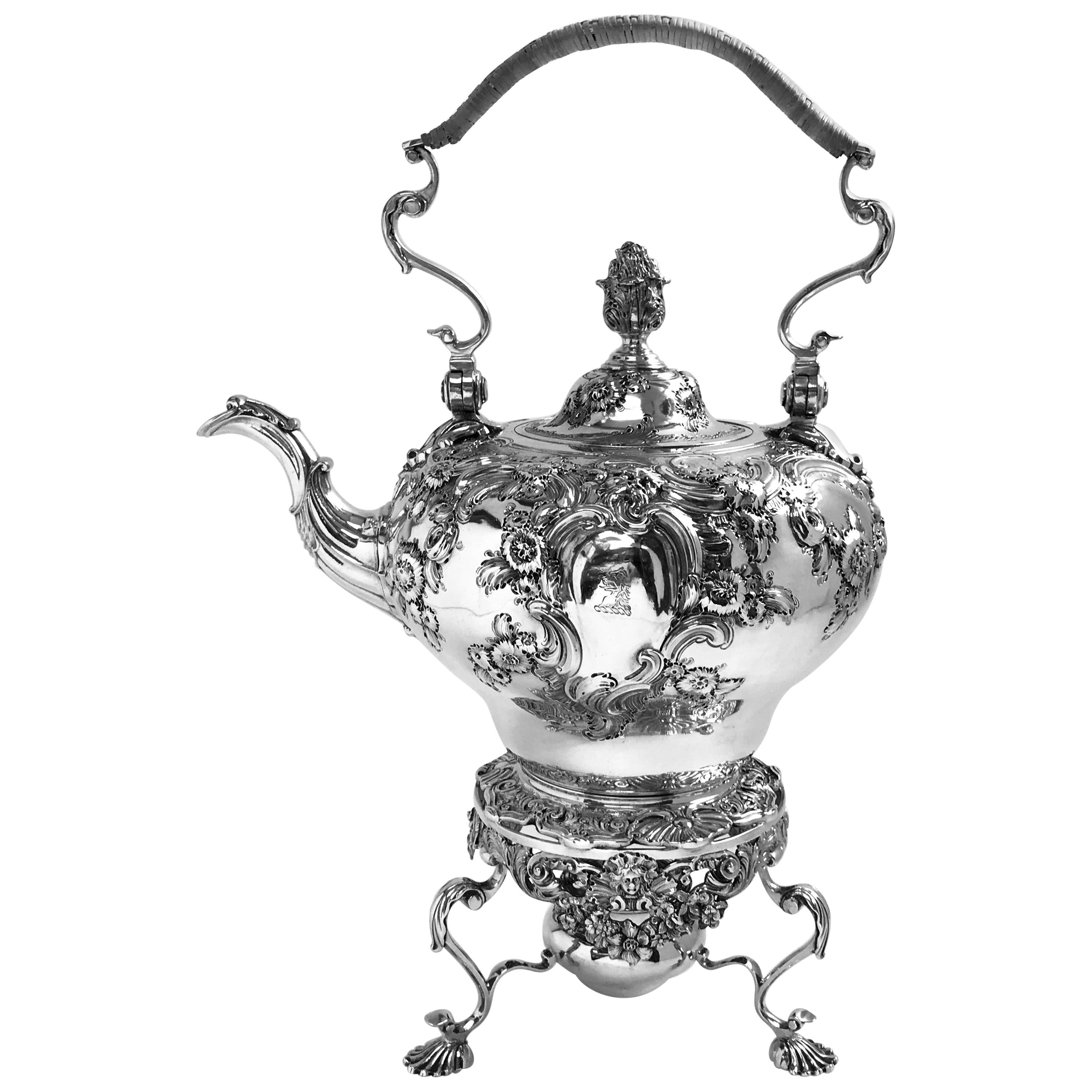 Antico bollitore inglese in argento di Giorgio II con supporto e lampada originali, cesellato e sbalzato in stile rococò. Il coperchio ha una cerniera a filo e il bollitore ha un manico in vimini.
I creatori, Thomas Cooke e Richard Gurney, erano