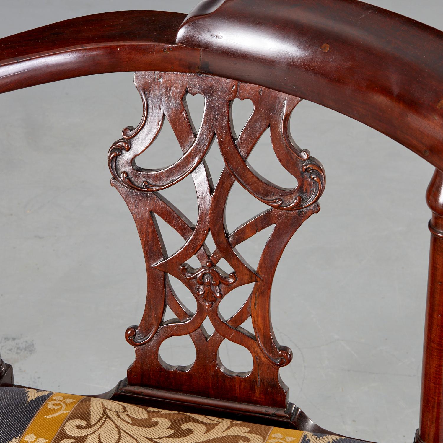 Late 18th/ Early 19th c., English George III carved mahogany corner chair with each side with pierced splats below a curved chair rail, the drop in seat above a X form stretcher joining square legs. The seat is upholstered in a yellow, gold and pale
