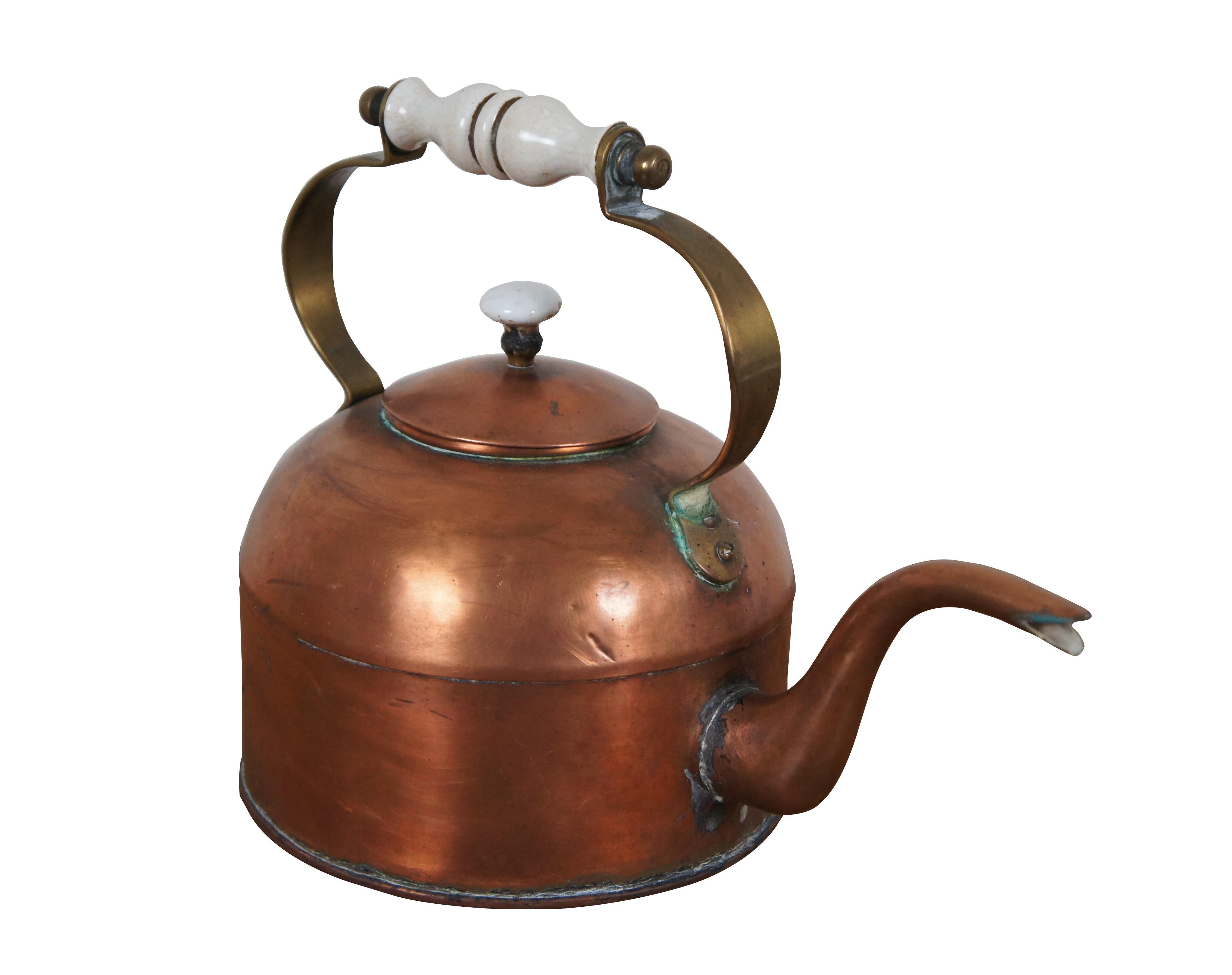 Late 18th century George III copper tea / water / coffee kettle with right angle gooseneck / bird spout, fixed brass handle with turned ceramic / porcelain grip and mushroom shaped porcelain finial on the lid.

Dimensions:
12.25