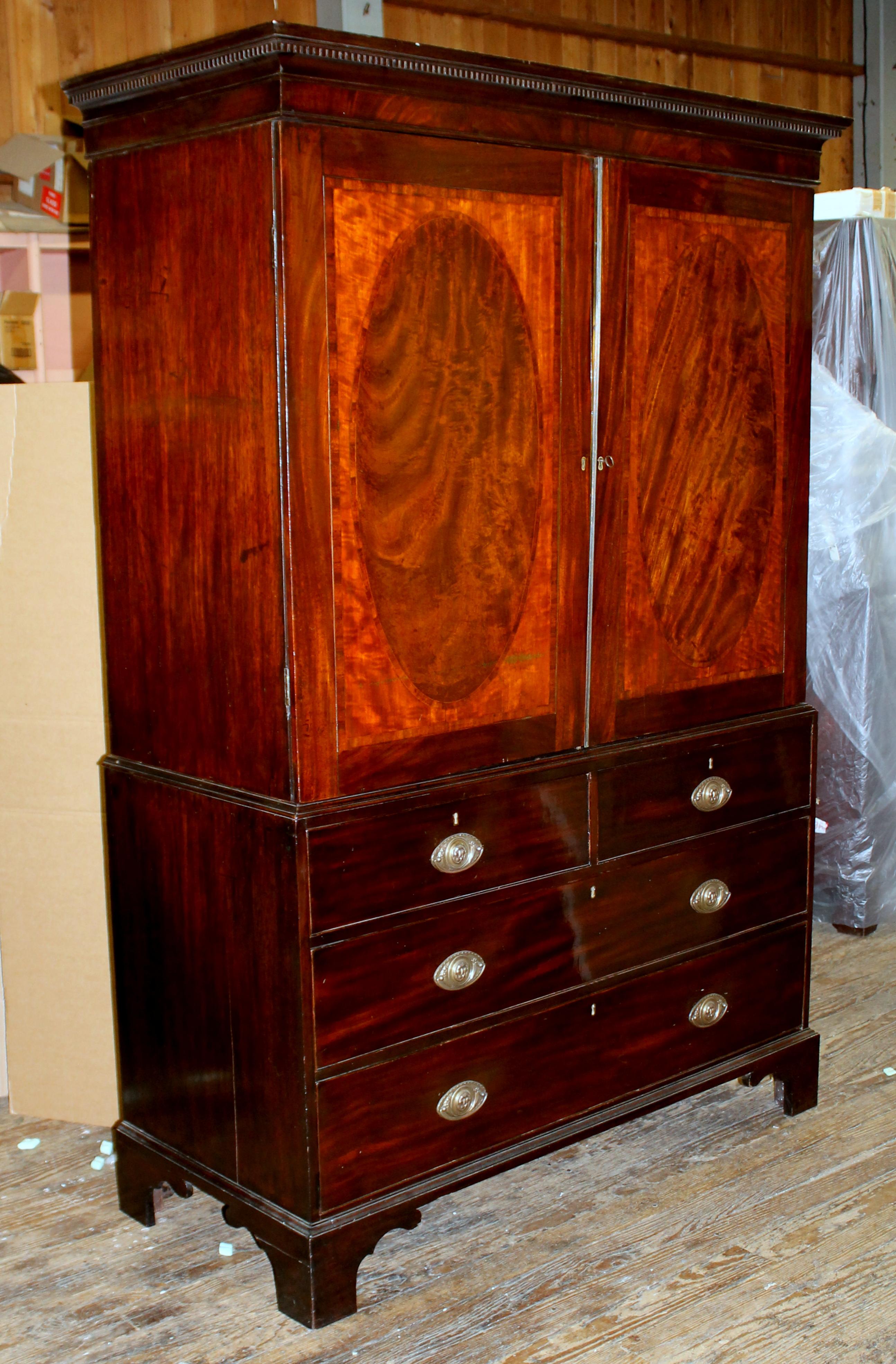 Fine quality antique English George III Inlaid mahogany linen press with original trays; fabulous inlaid oval 