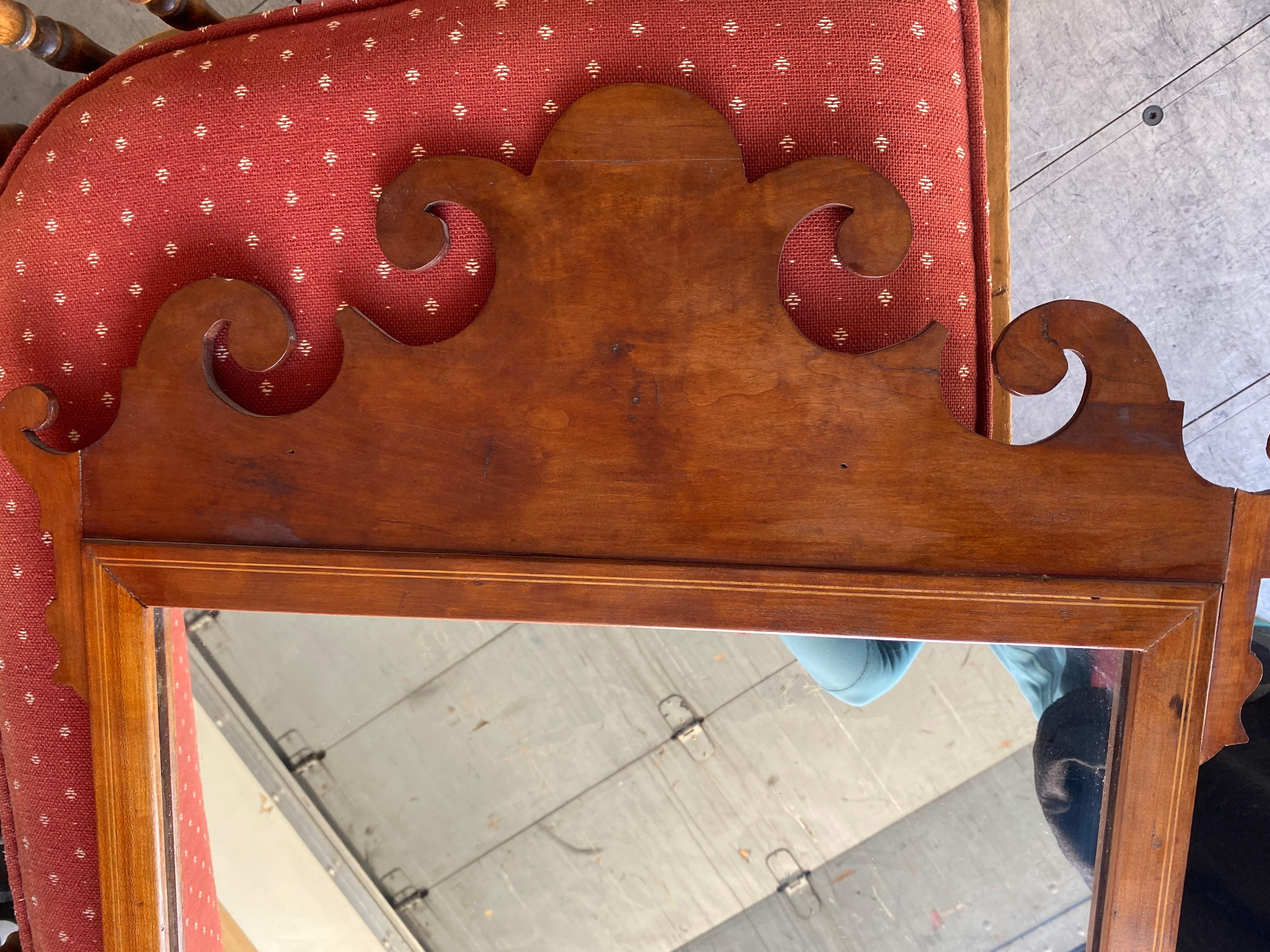 Very fine quality Antique English George III Walnut mirror, 18th C. The mirror has a shaped crest with scrolls. The rectangular mirror plate is fitted within a rectangular molded frame above a shaped scrolled apron. Condition is excellent with a