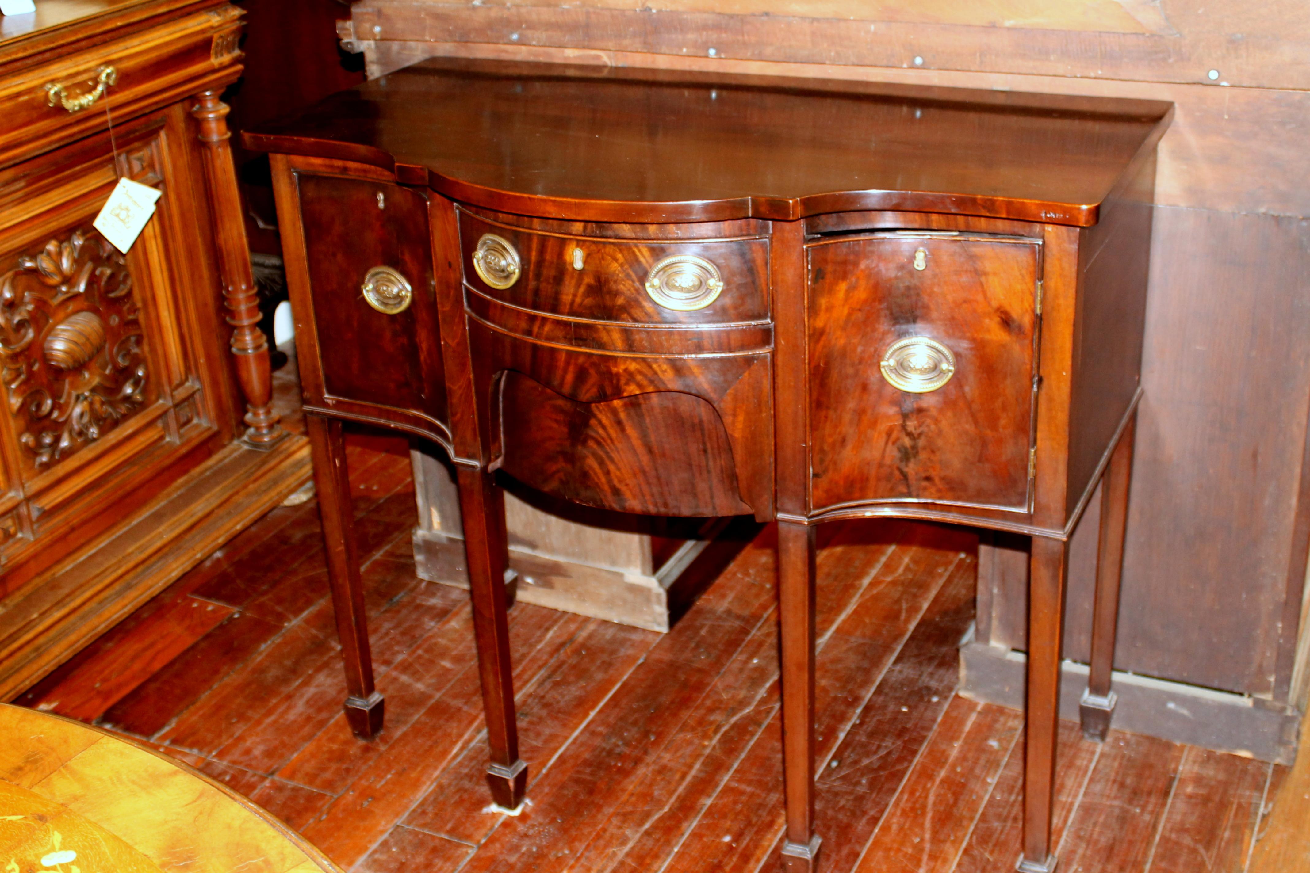 Superb and rare antique English George IV diminutive size highly figured mahogany Hepplewhite style serpentine sideboard. Unusual, small size with fabulous deep serpentine shaped front.

Please note the wonderful, useful lower center storage