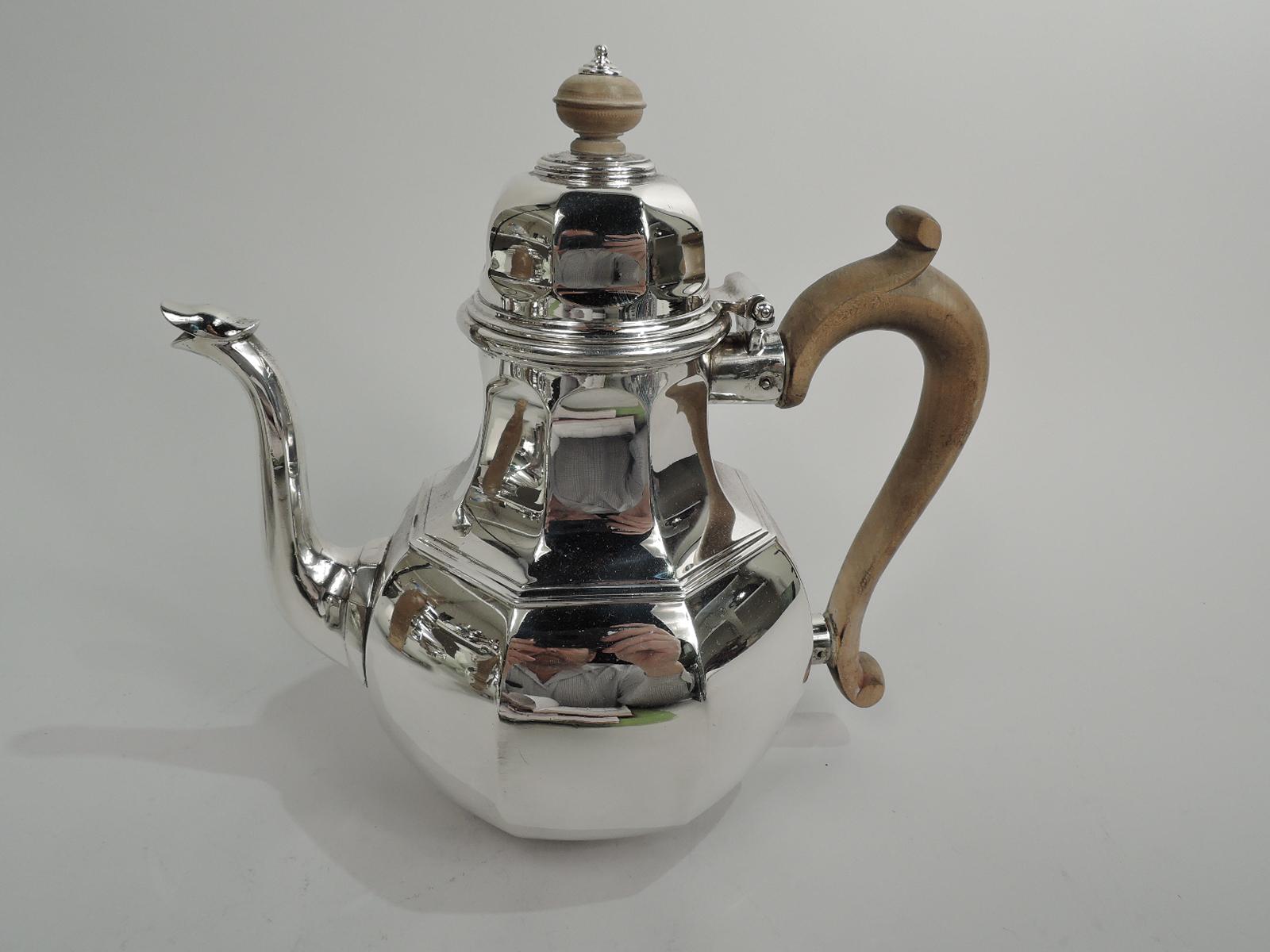 English Georgian silver coffee & tea set, 1919. This set comprises 4 pieces: Coffeepot, teapot, hot milk jug, and creamer. Faceted and globular bodies. Capped and s-scroll stained-wood handles. Covers hinged and domed with stained-wood and silver