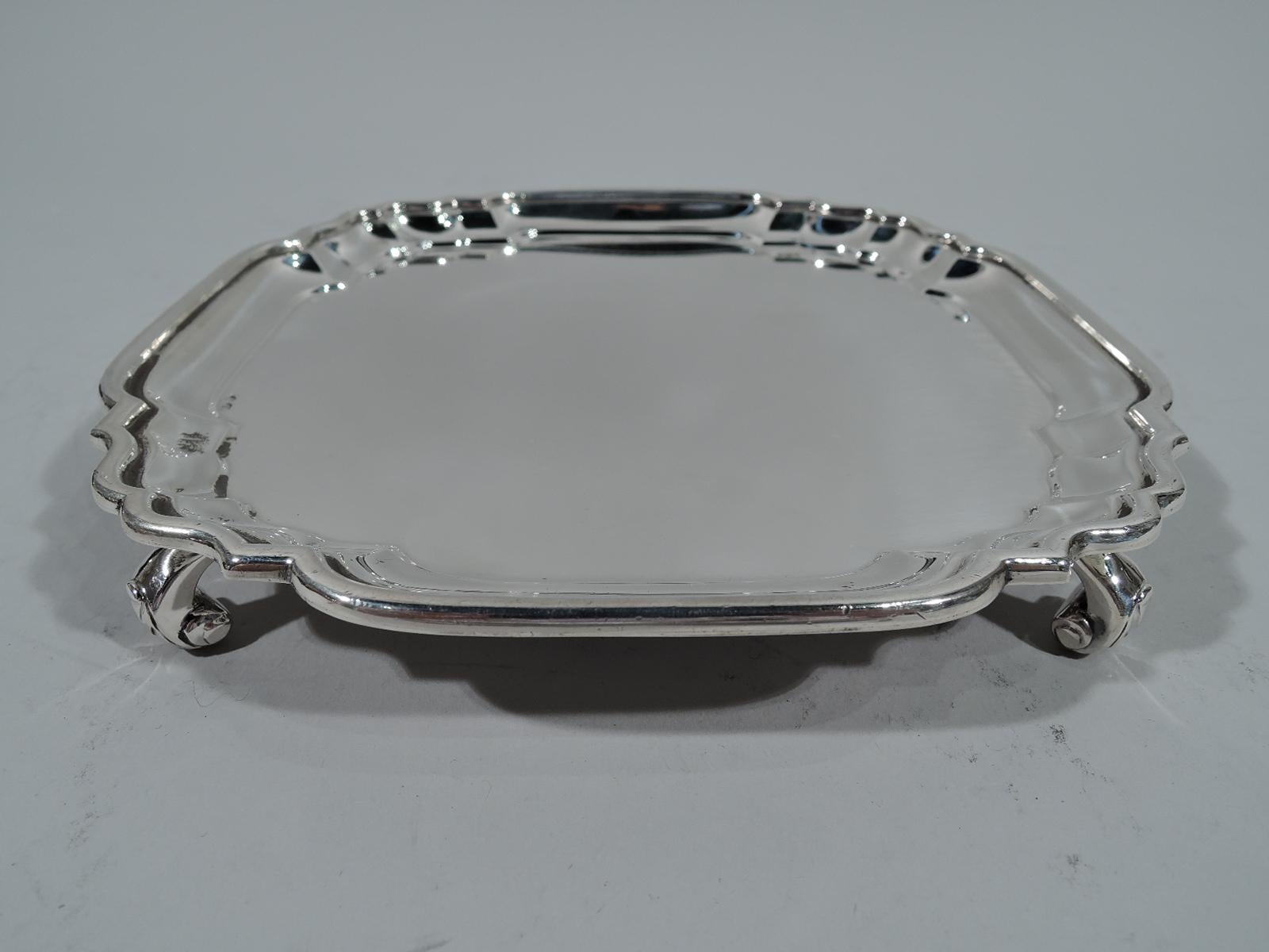 Traditional Georgian salver in Britannia (that is 958) silver. Made by Lionel Alfred Crichton in London in 1930. Square with molded rim and scrolled corners. Corner leaf-capped volute scroll supports. Hallmarked. Weight: 8.5 troy ounces.