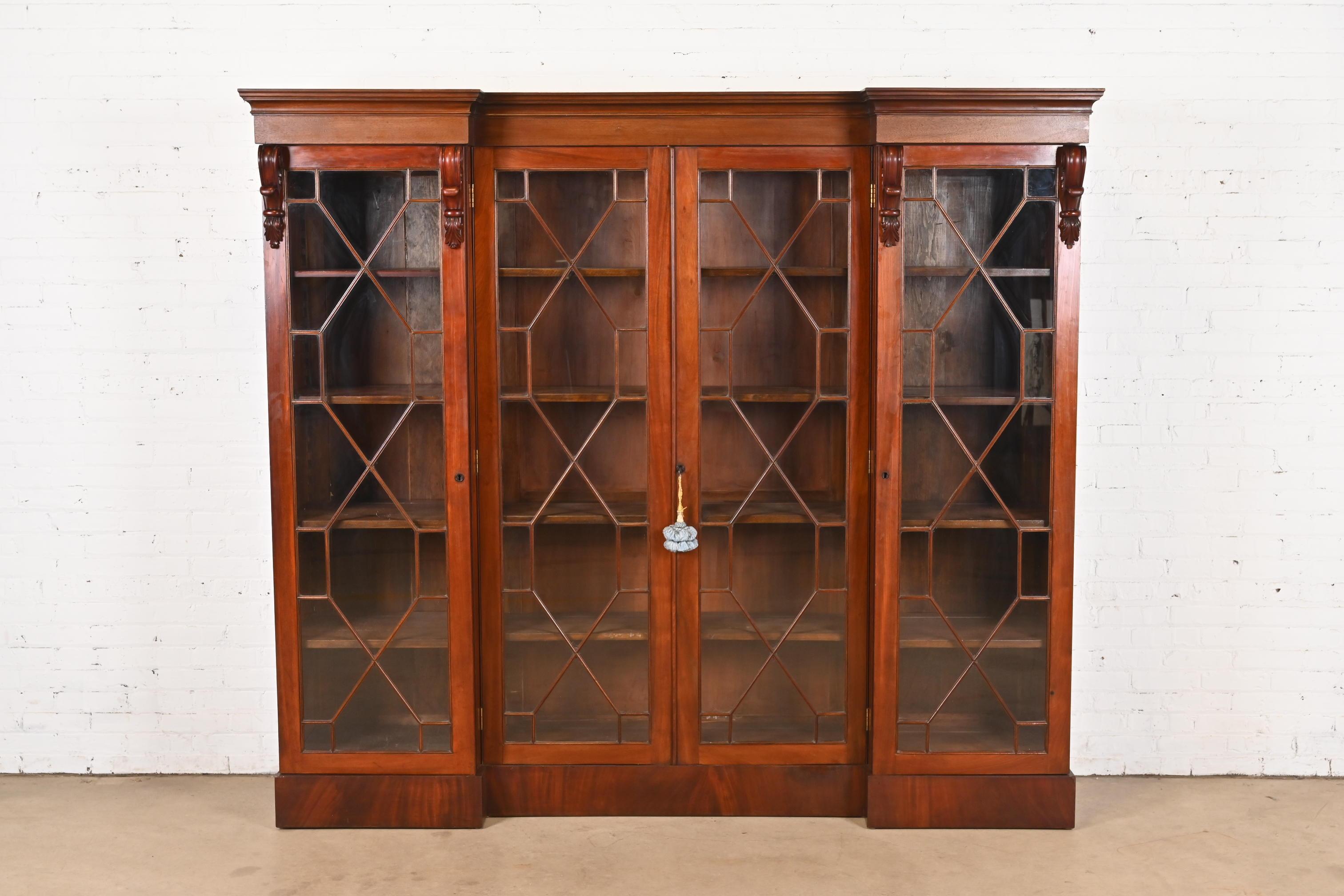 Magnifique meuble bibliothèque antique à quatre portes, de style géorgien ou Chippendale.

À la manière des meubles Baker

Angleterre, Vers 1900

Acajou flammé sculpté, portes avant en verre à meneaux. Les étagères intérieures sont