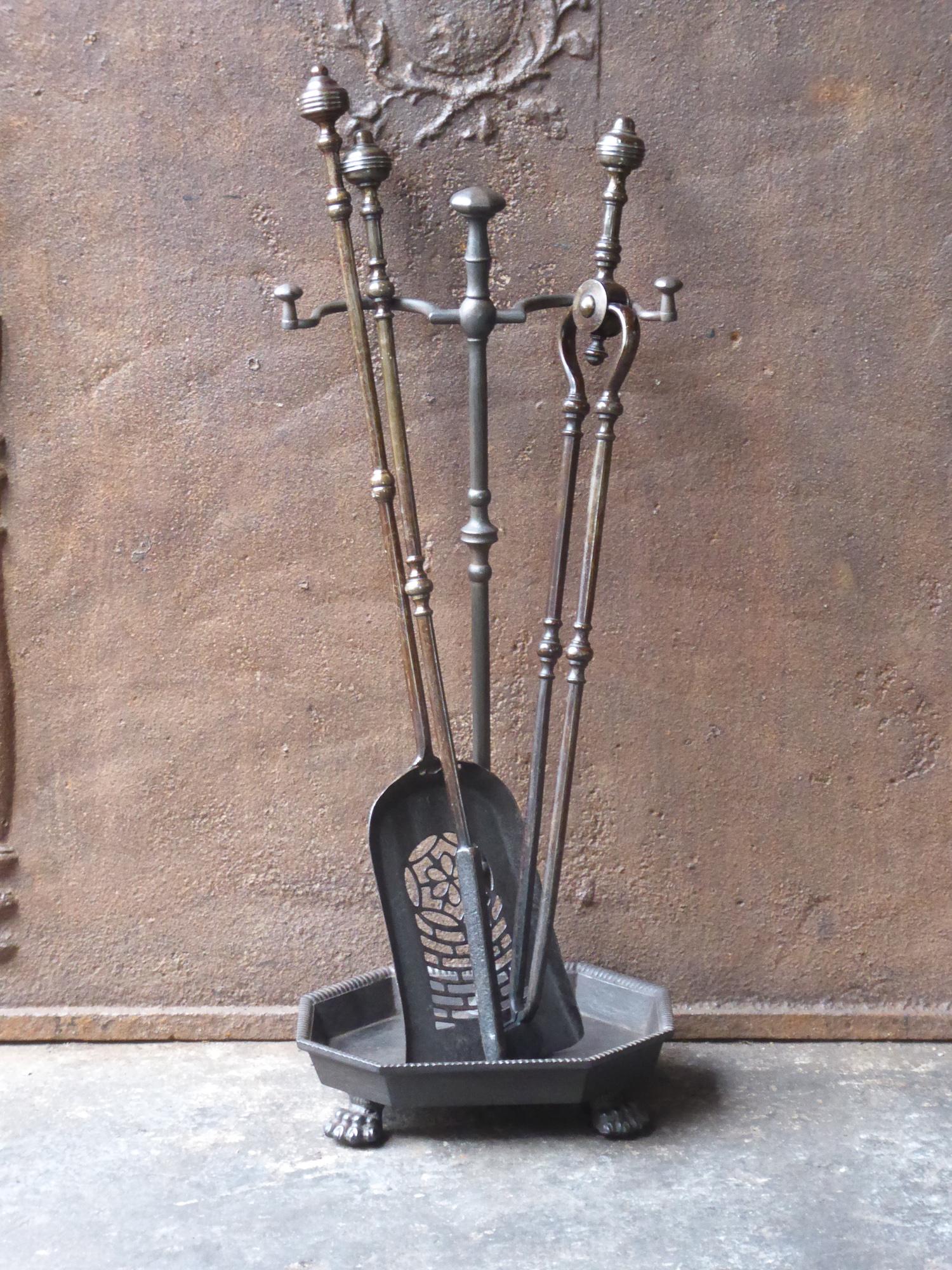 Late 18th or early 19th century English Georgian fireplace toolset. The toolset is made of cast iron and wrought iron. It is in a good condition and is fully functional.