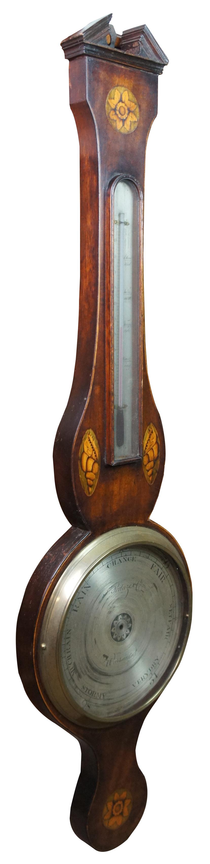 Antique English George III fruitwood barometer featuring a banjo shape with open pediment and inliad satinwood sea shell and floral motif. Made by F. Peduze Co. Circa 1780s-1820s. Measures: 38