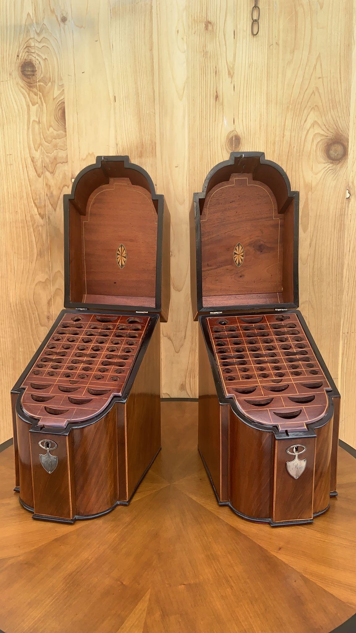 Antique English Georgian III Mahogany Knife Boxes - Pair 

A fine pair of English mahogany knife boxes with slanted hinged lids and shaped fronts. The interior with inlaid satinwood, carved slots for different knives and sterling silver mounts. The