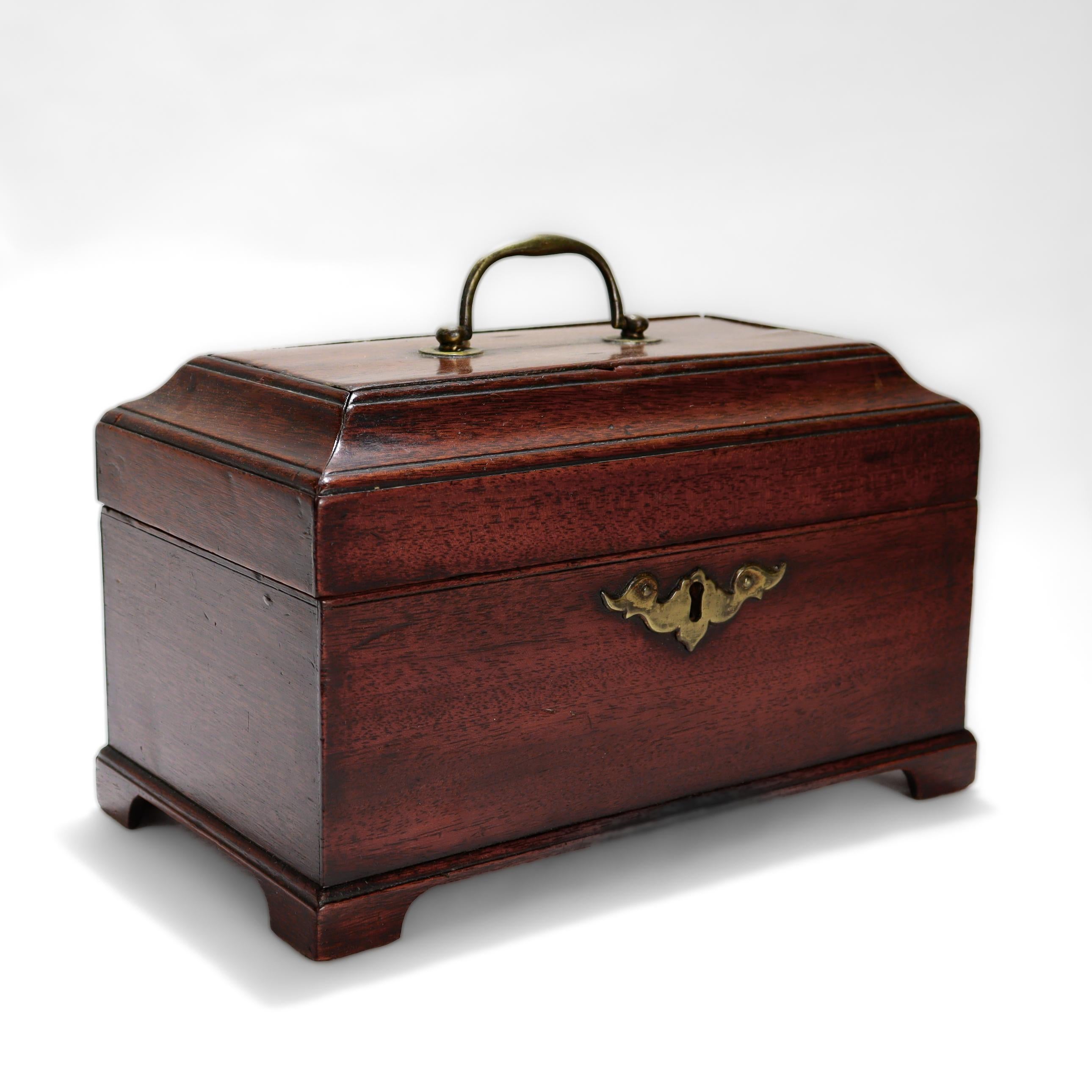 Une belle boîte à thé anglaise ancienne.

En placage d'acajou avec un support en pin avec un lavis rouge.

Avec un couvercle en gradins, un corps rectangulaire et des pieds en forme d'équerre.

Monté avec un écusson en laiton et une poignée en
