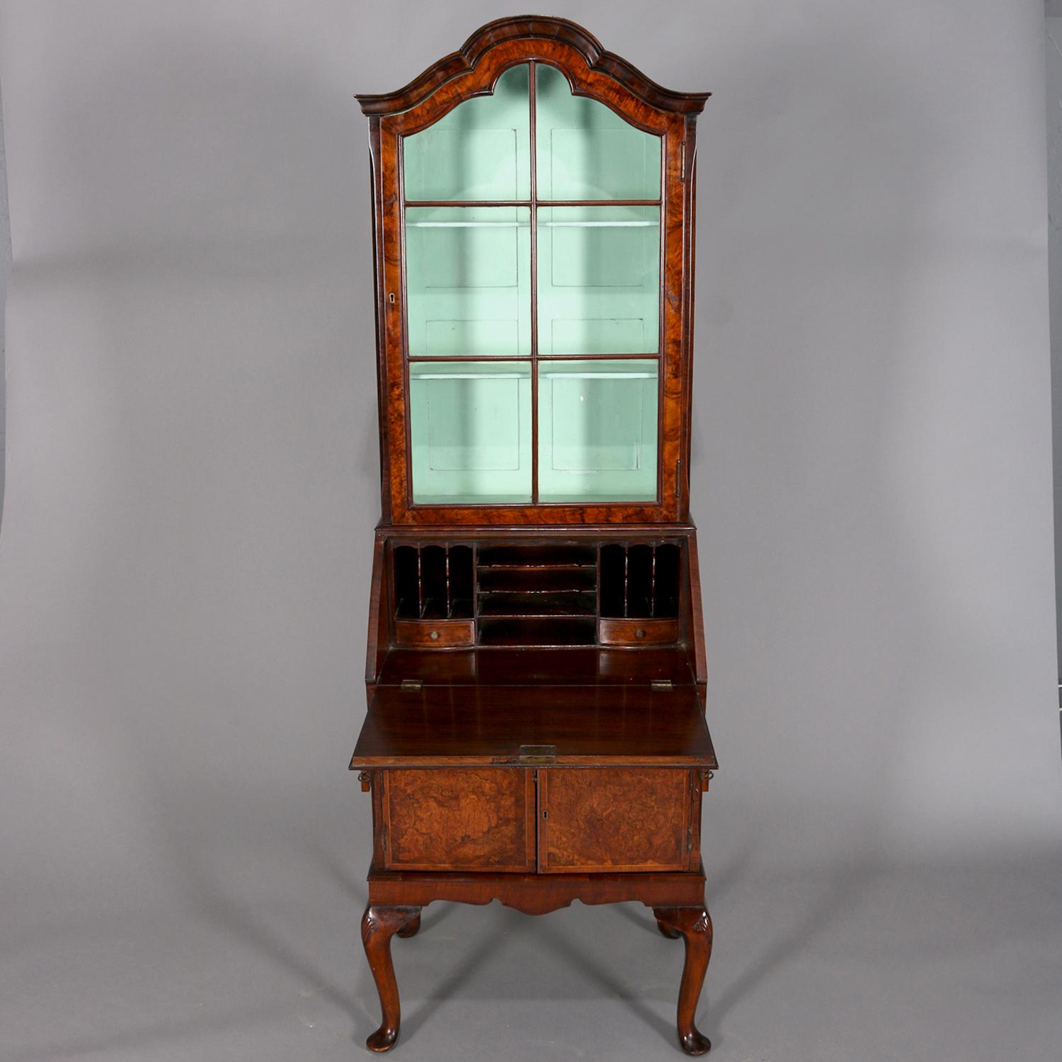 Antique English Georgian petite secretary features burled walnut with upper bookcase with shaped crest over single glass door opening to shelved interior and above desk with slant front opening to writing surface with interior drawers and pigeon