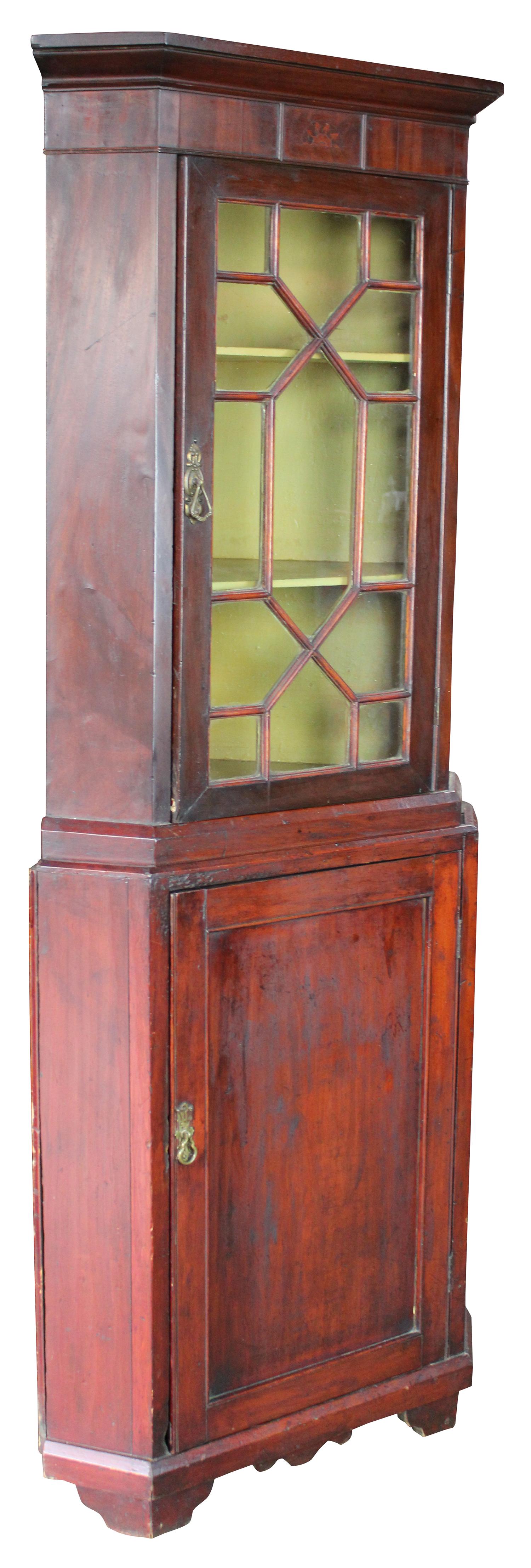 Antique petite Georgian style corner cupboard. Made from mahogany with a yellow painted interior and brass handles. Display door is lined in elegant fretwork to neatly display curiosities. Measure: 72”.
   
