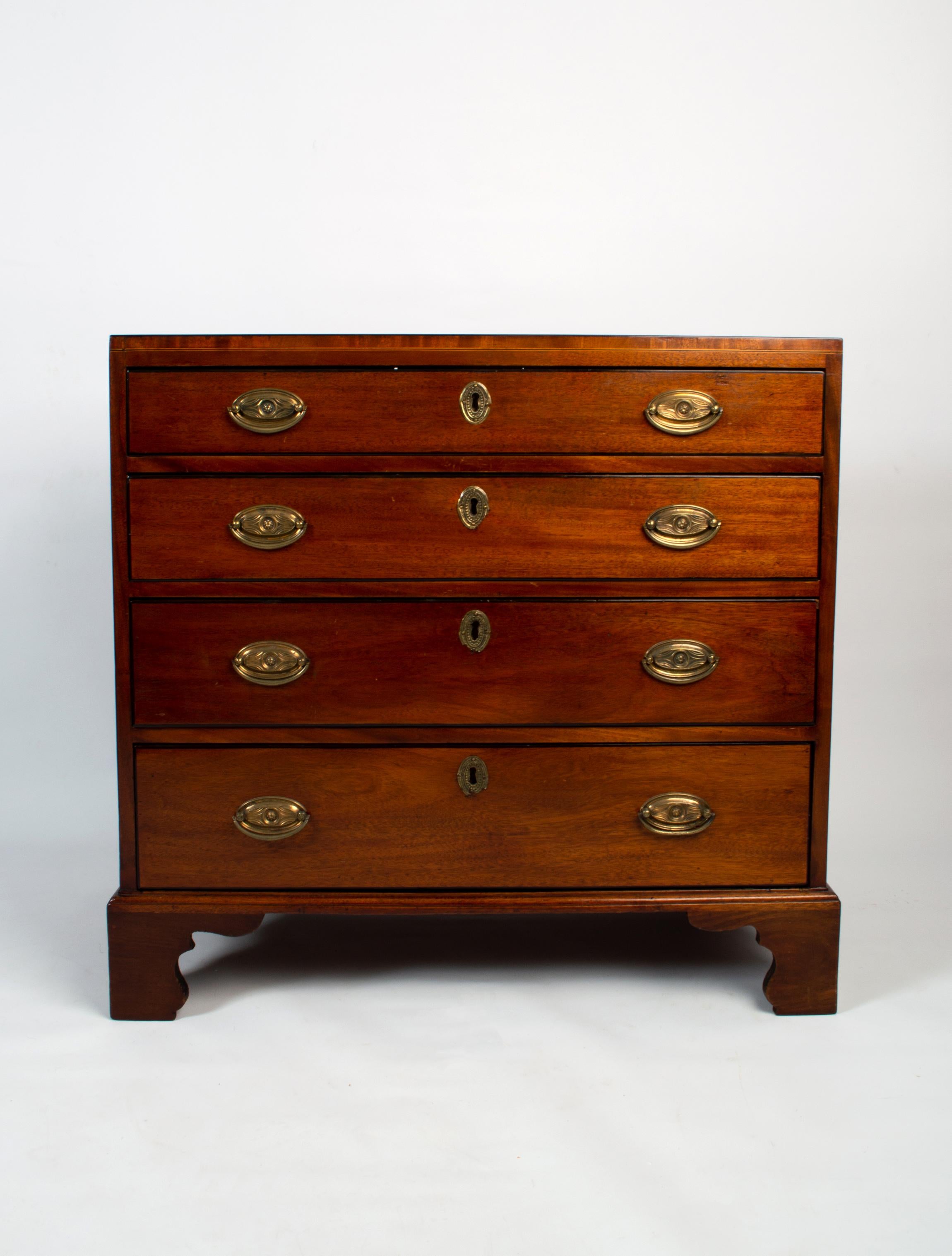 Antique English Georgian mahogany diminutive chest of drawers

A small-scale George II chest of drawers. 
Dating circa 1750

Comprised of four long graduating drawers with original brass oval pull handles and escutcheons. Standing on bracket