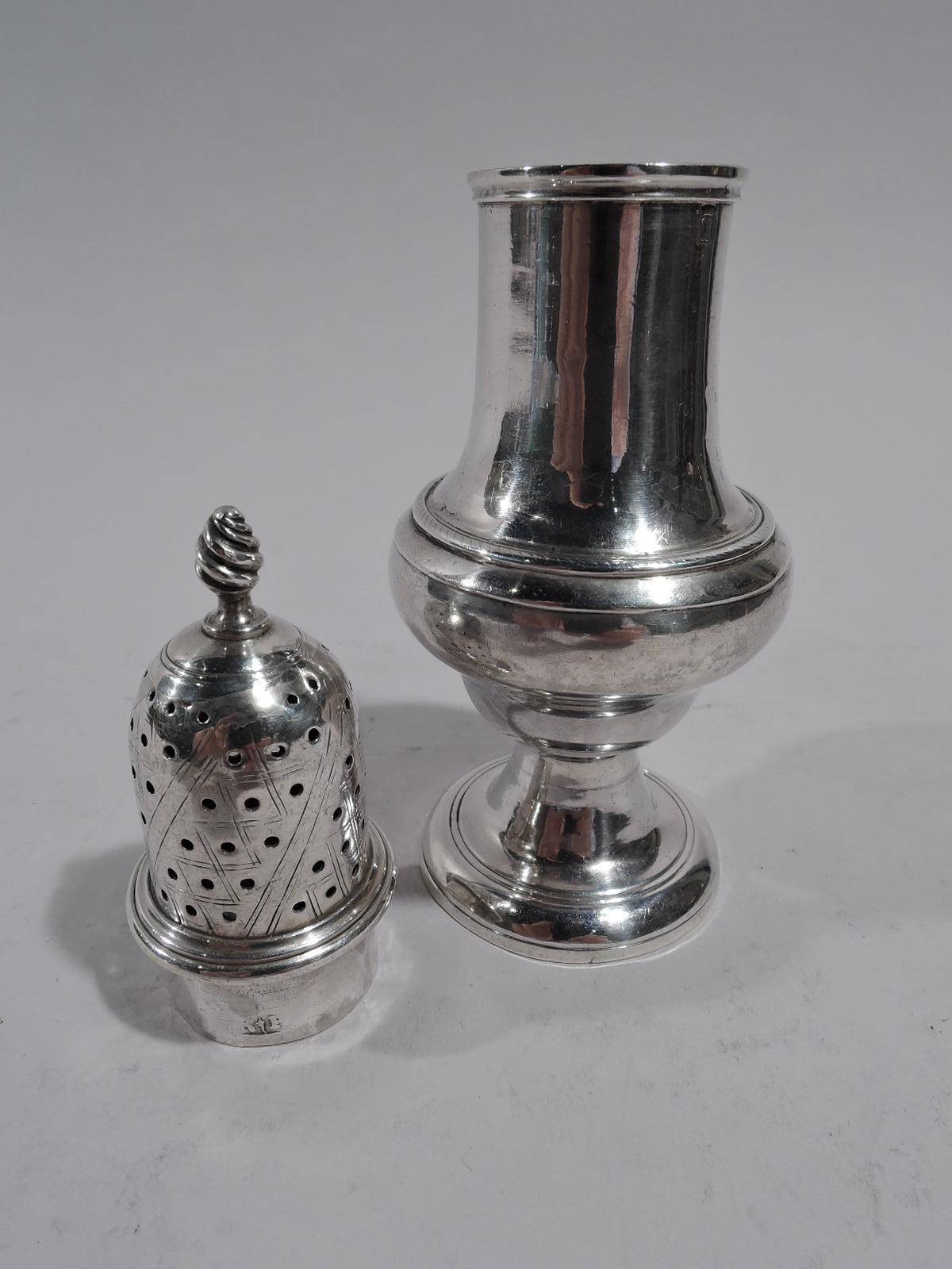 Saupoudreuse à condiments en argent sterling de style géorgien anglais, fin du 18e siècle. Balustre sur pied relevé. Couvercle percé d'une couche gravée et d'un fleuron torsadé. Les marques d'usure comprennent un T couronné (corps) et un V couronné