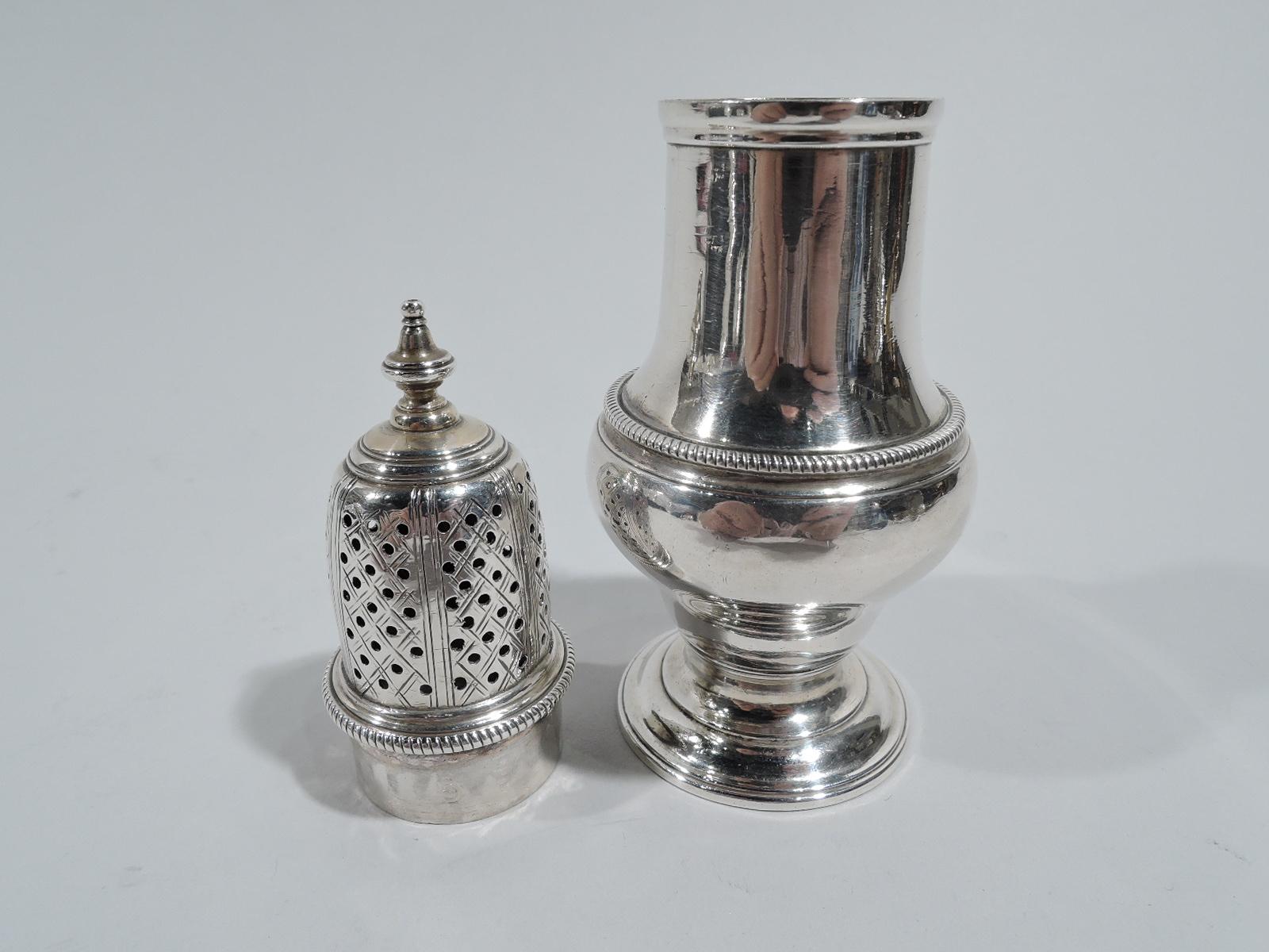 English Georgian sterling silver condiment shaker, late 18th century. Baluster on round and stepped foot. Cover pierced with engraved diaper and vasiform finial. Gadrooning. Body marks include London assay stamp, 1788 date later, and unidentified