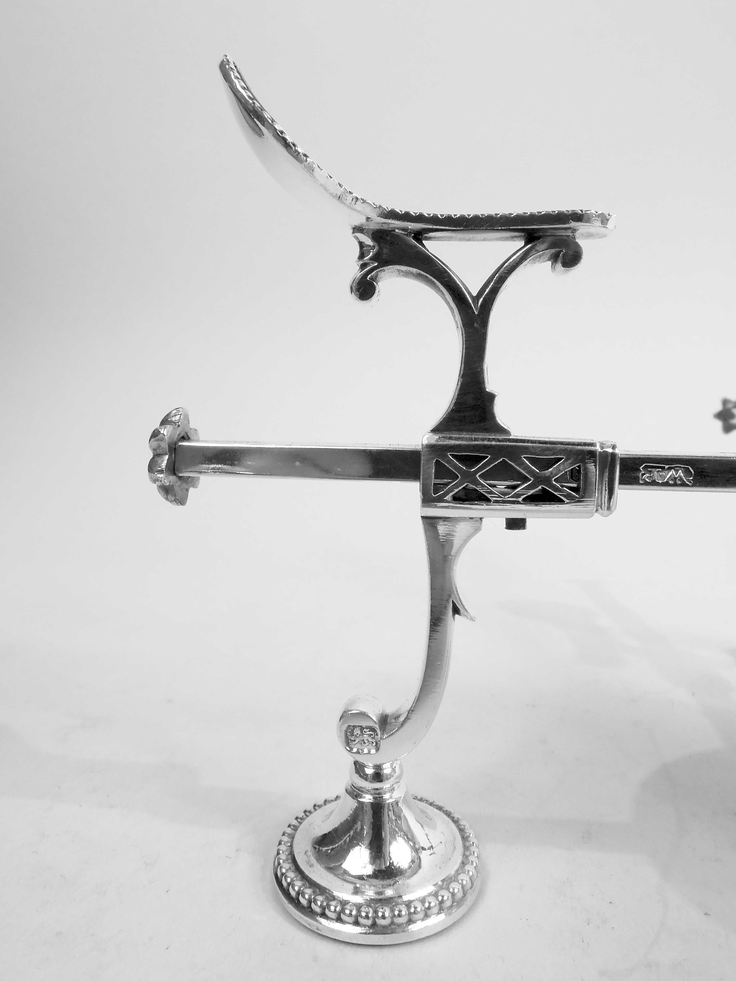 George III sterling silver dish cross. Made by William Plummer in London in 1783. Central baluster spirit lamp to which are mounted two bars; two more bars mounted to rotating top. Each bar has slide-adjustable cradle and end guard in form of cast