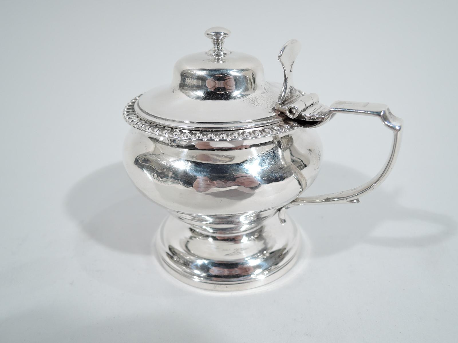 George IV sterling silver mustard pot. Made by Thomas Jenkinson in London in 1824. Bellied bowl with egg-and-dart border on raised foot. Scroll bracket handle and hinged and domed cover with finial. Fully marked. Weight: 4 troy ounces.
