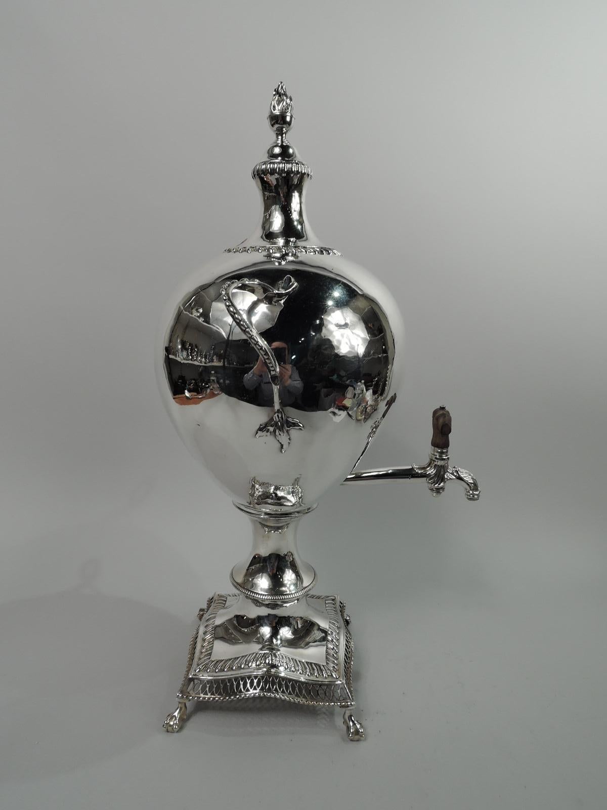 George III sterling silver tea urn. Made by Francis Butty & Nich Dumee in London in 1767. Ovoid bowl with leaf-mounted and beaded twisted side handles. Horizontal leaf-capped spout with leaf-mounted ornamental twist tap in stained wood. Cover domed
