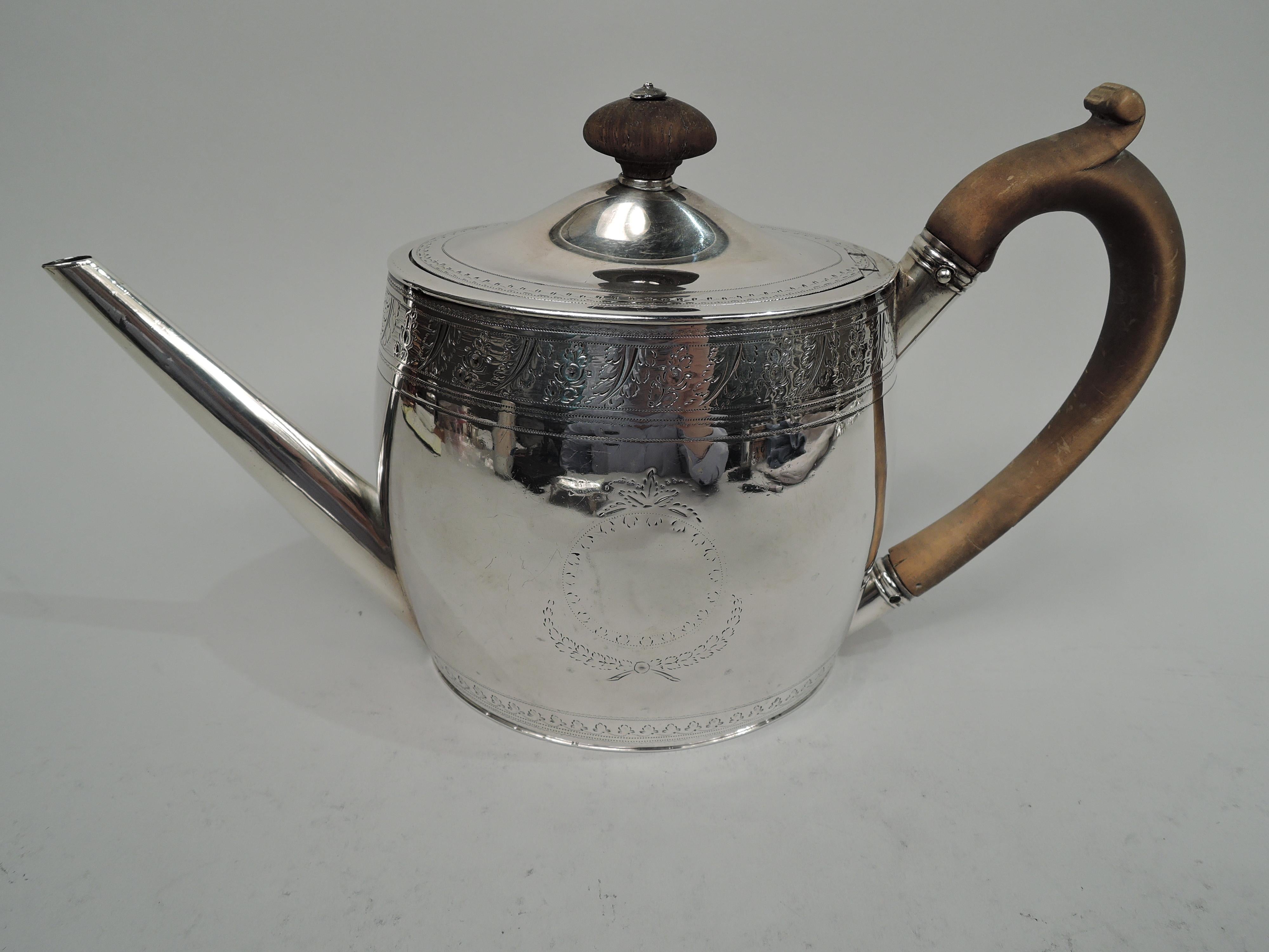 George III sterling silver teapot. Made by George Smith & Thomas Hayter in London in 1795. Ovoid body with straight diagonal spout and capped. Cover hinged and gently raised. Cover finial and capped high-looping handle are stained wood. Ornamental
