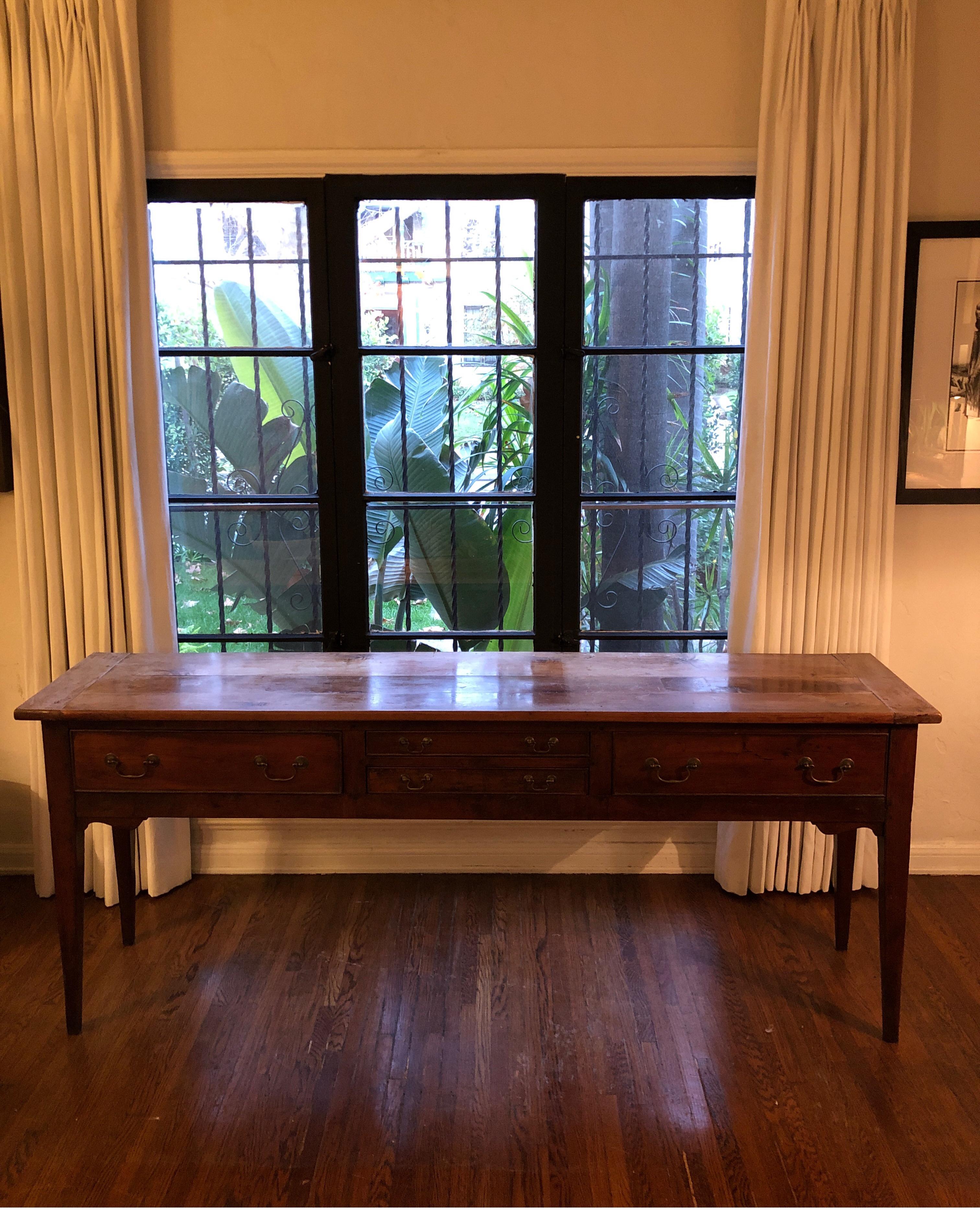 Antique English oak dresser base with 4 drawers(Two large and two smaller in the center). Bronzed hardware.
Square tapered legs. Thick top. Walnut finish on base in good condition. Top shows signs of wear with patina and fading. See