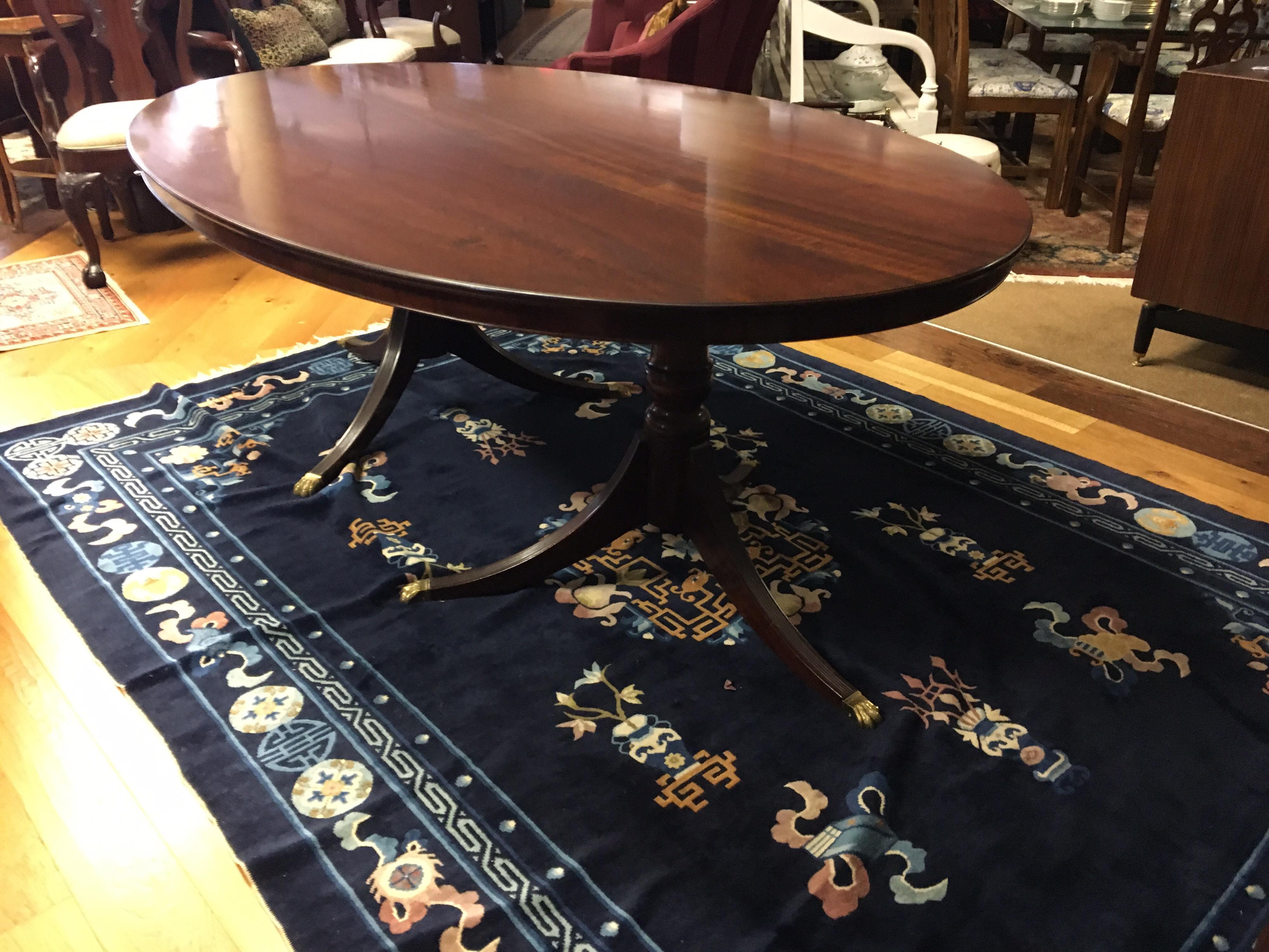 England, mid-19th century stunner, this mahogany Georgian oval table is sure to impress. Top is one piece of wood and rests on double pedestals with brass feet. No leaves.