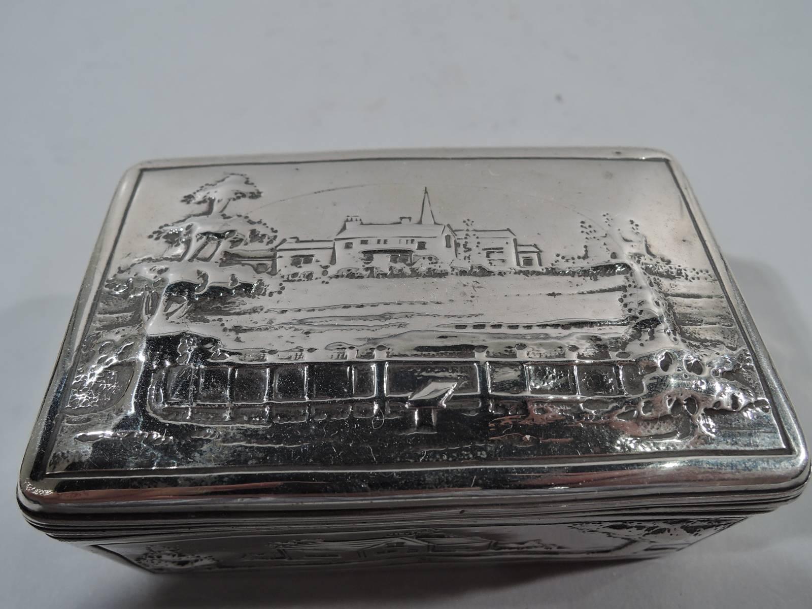 English Georgian sterling silver box with sweet pastoral scenes. Rectangular with reeded and hinged cover. Low-relief landscapes including a steepled church, turreted castle, and bridge. Hallmarked with silver standard, date letter, and George III