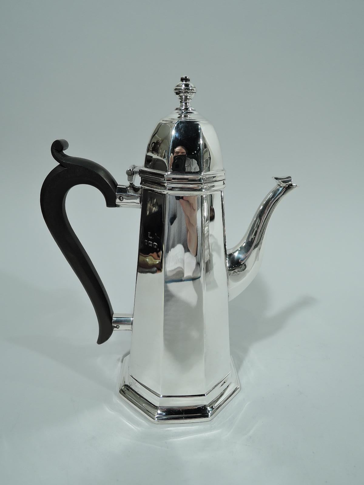 George V sterling silver coffeepot. Made by S. Blanckensee & Sons Ltd in Birmingham in 1925. Faceted with conical body, leaf-capped s-scroll spout, and hinged and domed cover with vasiform finial. Capped and scrolled stained-wood handle. Perennially