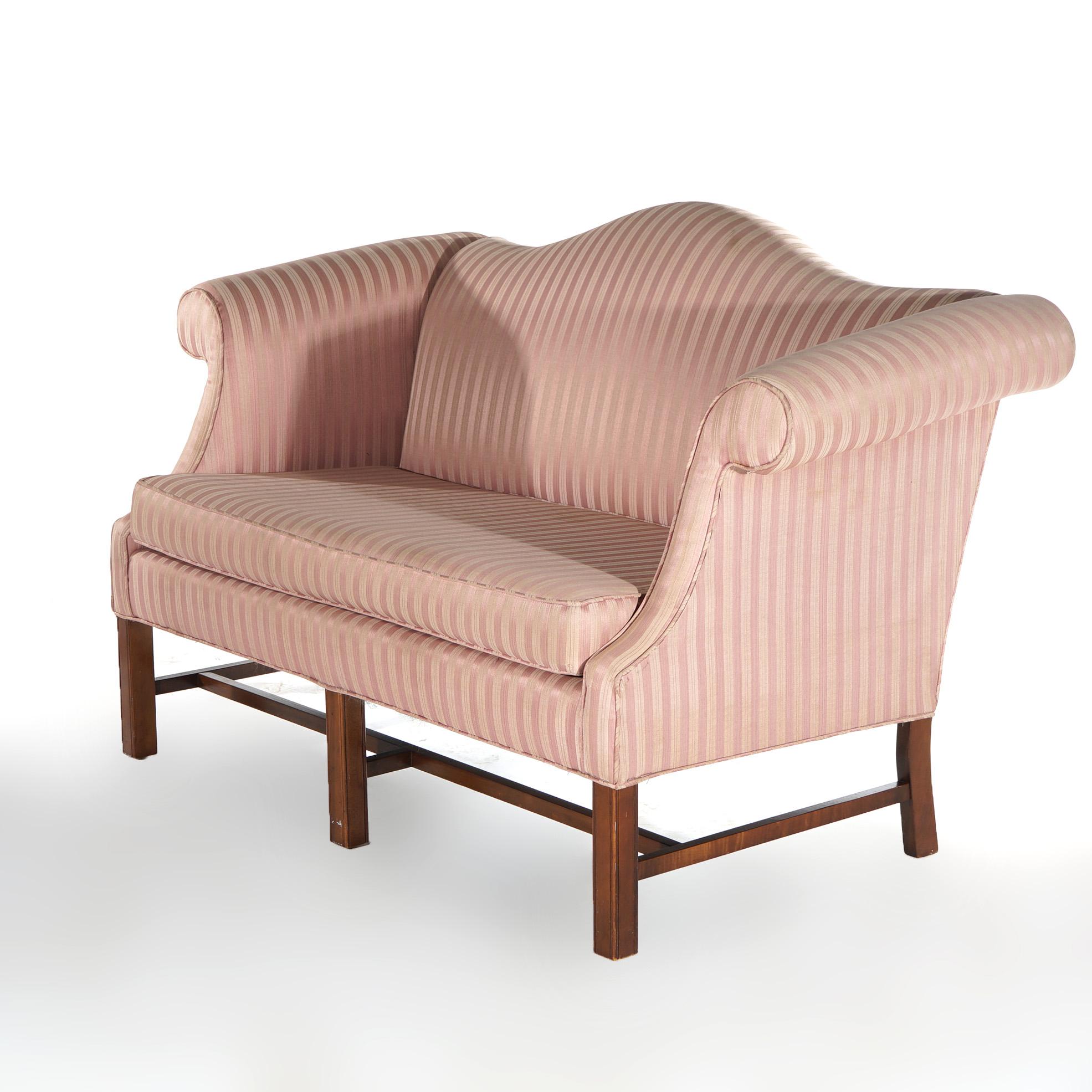 An antique English Georgian style settee offers upholstered camelback form with scroll arms and raised on straight legs, c1930

Measures - 36