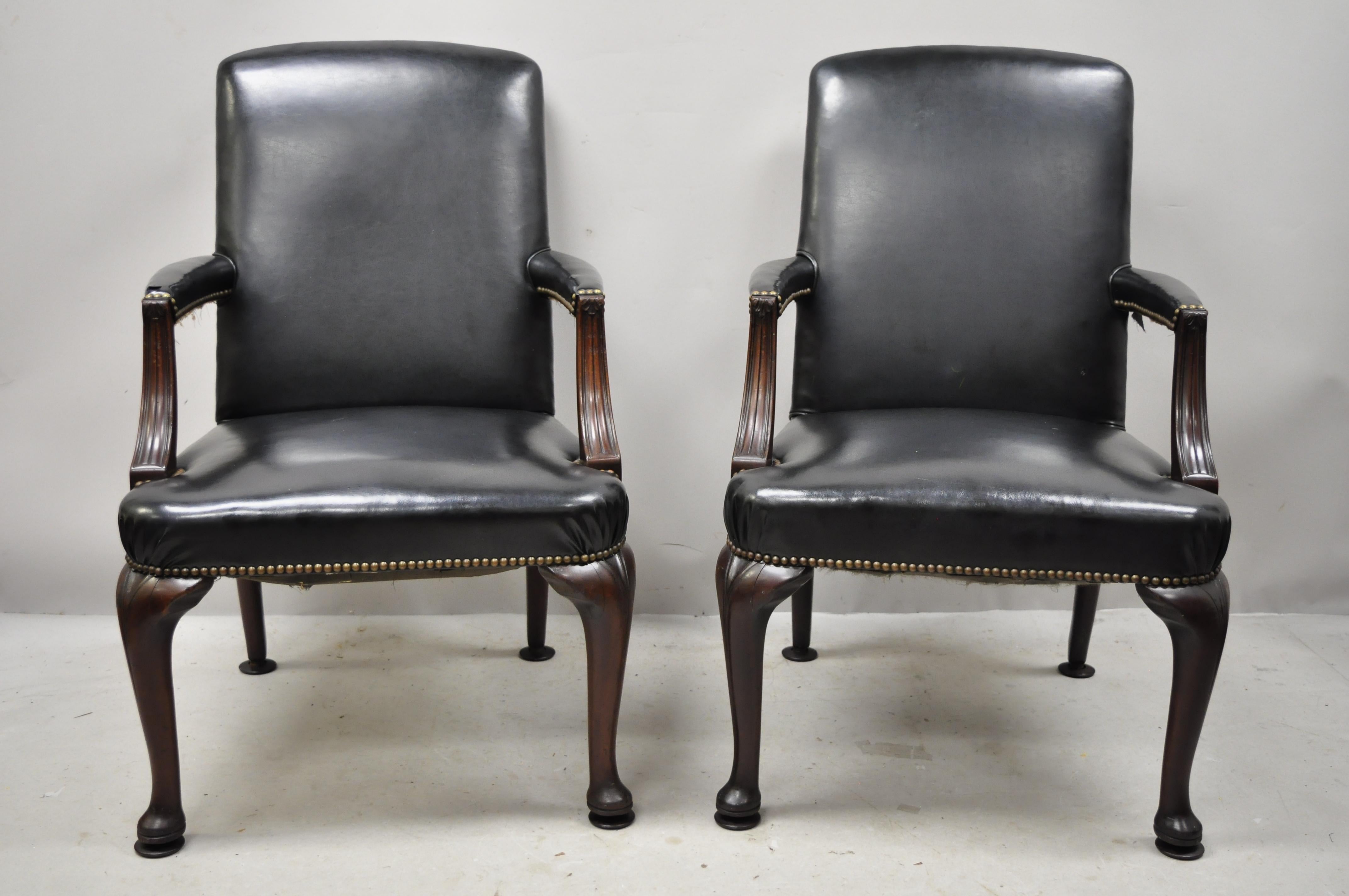 Antique English Georgian style dark green leather library office chairs - a pair. Item features nailhead trim, solid wood frame, upholstered armrests, dark green leather upholstery, very nice antique item, quality American craftsmanship. Currently