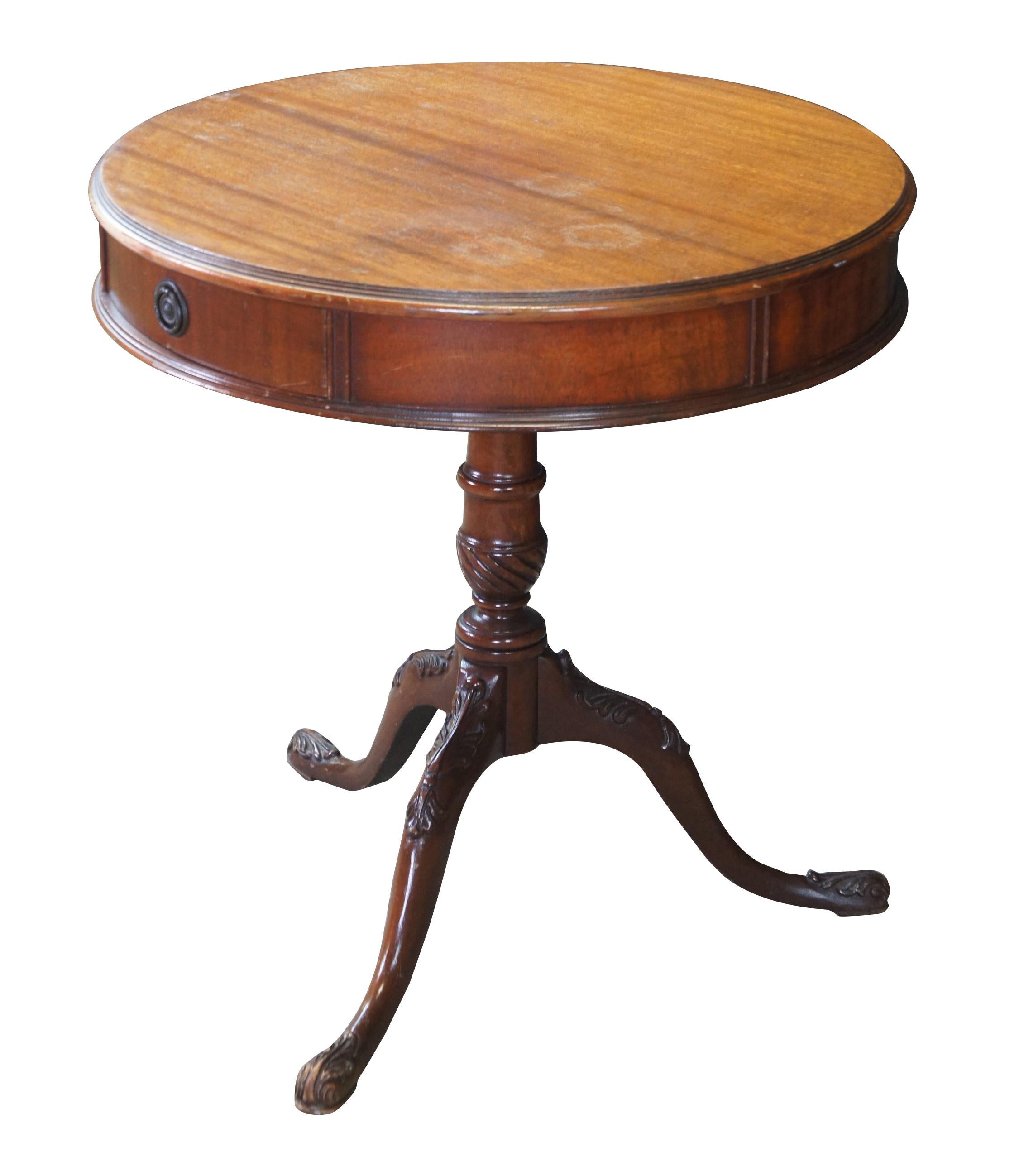 An antique Georgian style drum table.  Made from mahogany with rounded top featuring a drawer within the frieze over a turned and carved column leading to downswept tripod base with scrolled pad feet.  

Dimensions:
25.5