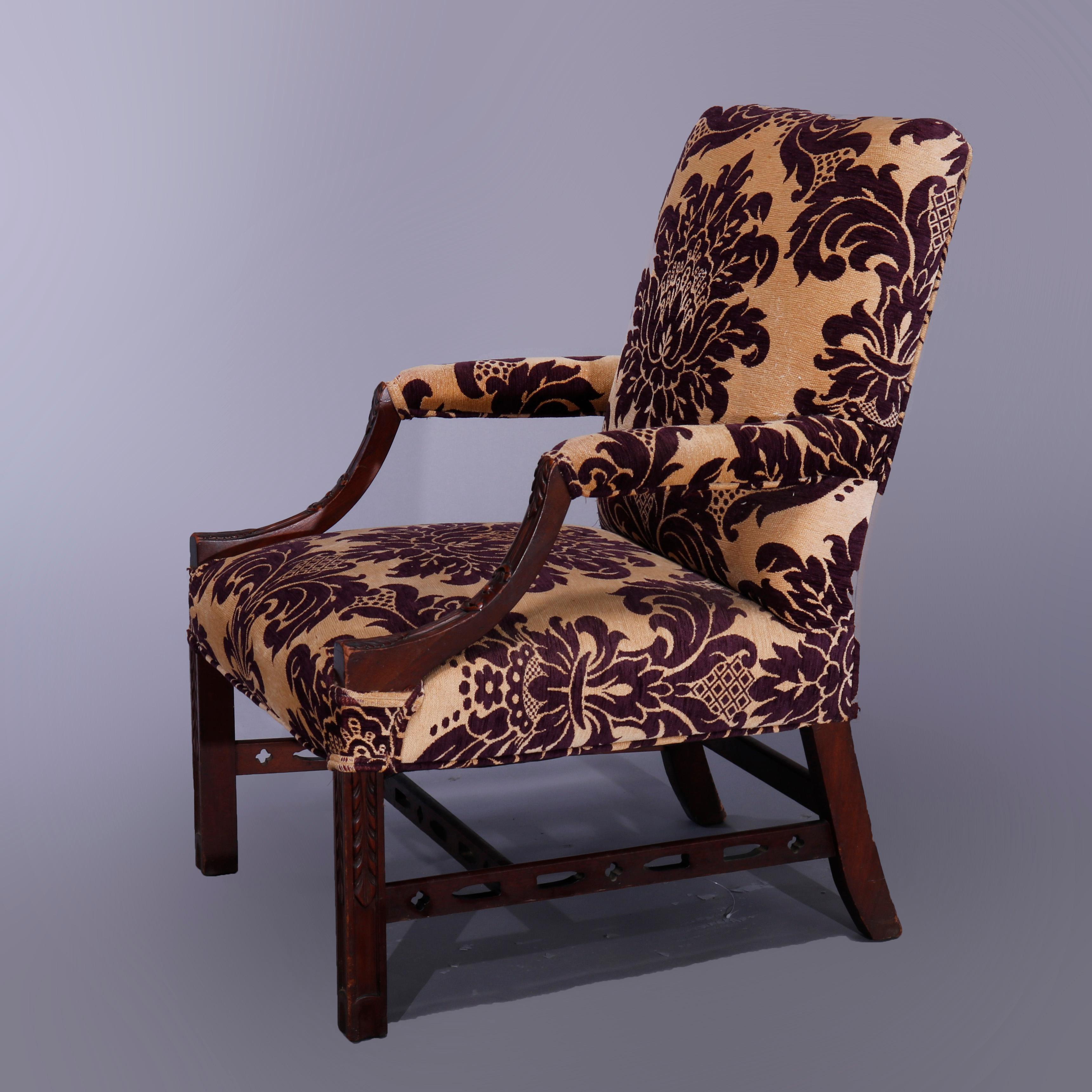 An antique English Georgian style lolling armchair offers mahogany frame having upholstered back, seat and arms with convex supports, raised on straight and square legs, c1920

Measures: 38.5