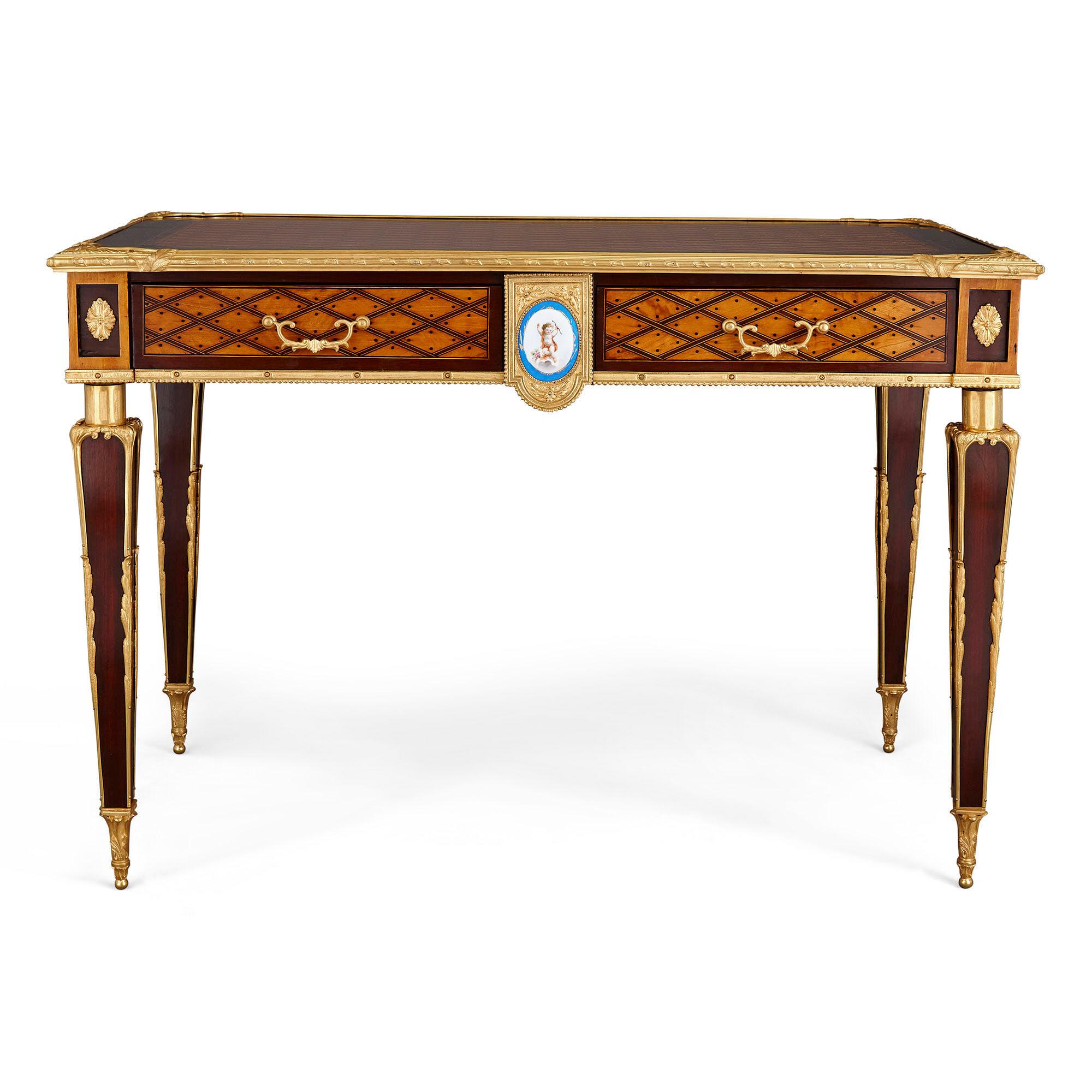 Antiguo escritorio inglés de bronce dorado y marquetería de Donald Ross
Inglés, c. 1890
Medidas: Alto 75cm, ancho 108cm, fondo 63cm

Este elegante escritorio de caoba de Donald Ross presenta la característica marquetería de puntos y enrejado de