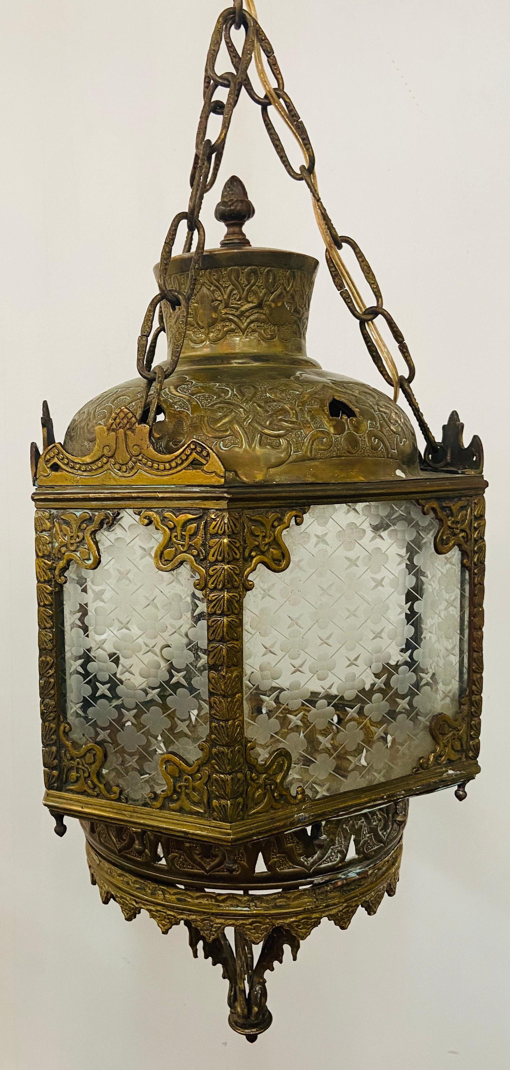 A fine antique English gilt bronze lantern featuring 6 panels with original handout glass. The glass panels are beautifully decorated with stars and clover leaf motifs. The hexagonal shaped hanging lanterns is a classy addition to your hallway or