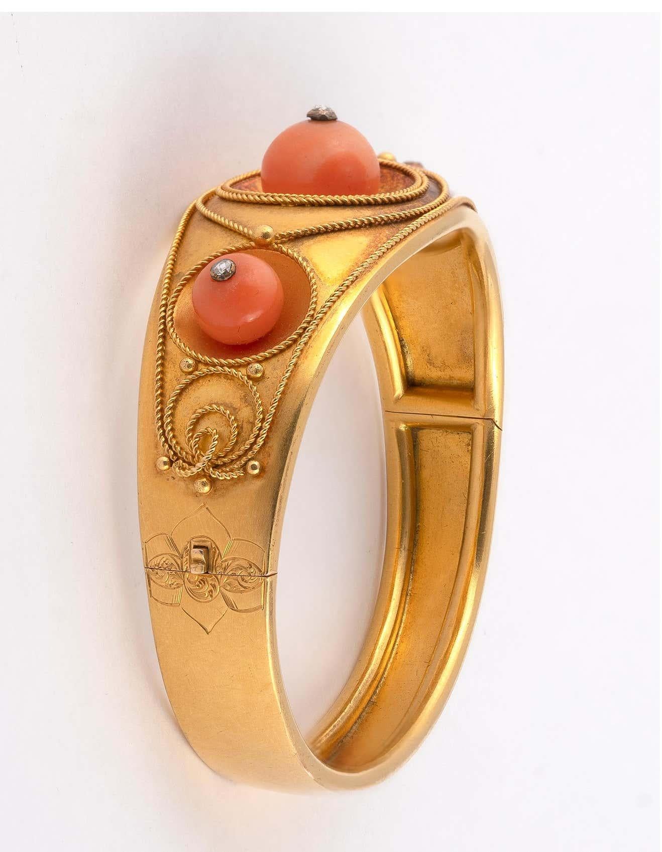 Rigid, articulated cuff-type bracelet in yellow gold,set with three corallum pearls topped by a small rose diamond in a filigree setting. English work, circa 1870's.  Total gross weight: 22.95g;  Diam. 5.6 cm